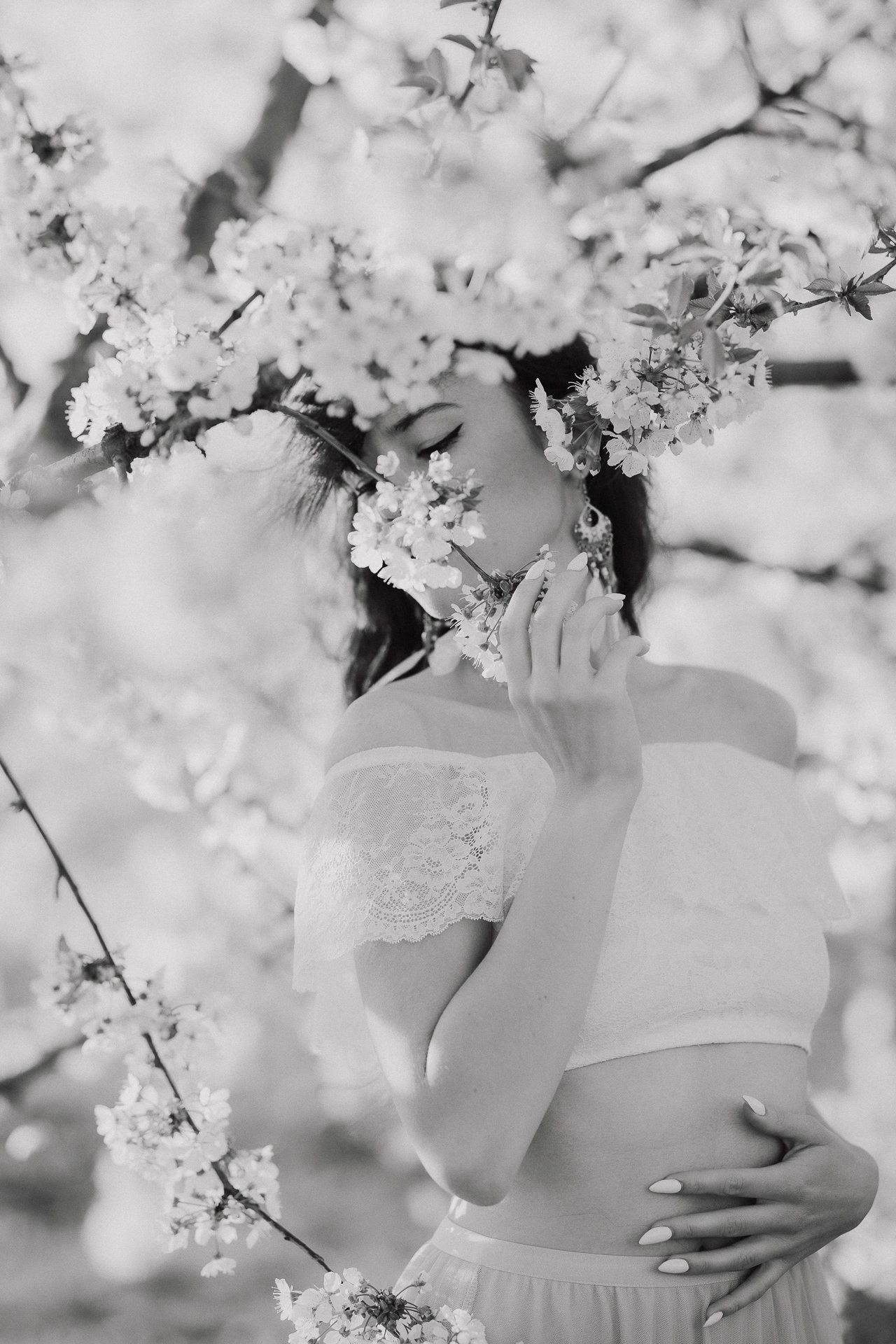 Kobieta zakryta kwiatami w kwitnącym sadzie jabłoniowym, profesjonalna fotografia kobieca, okolice Krakowa