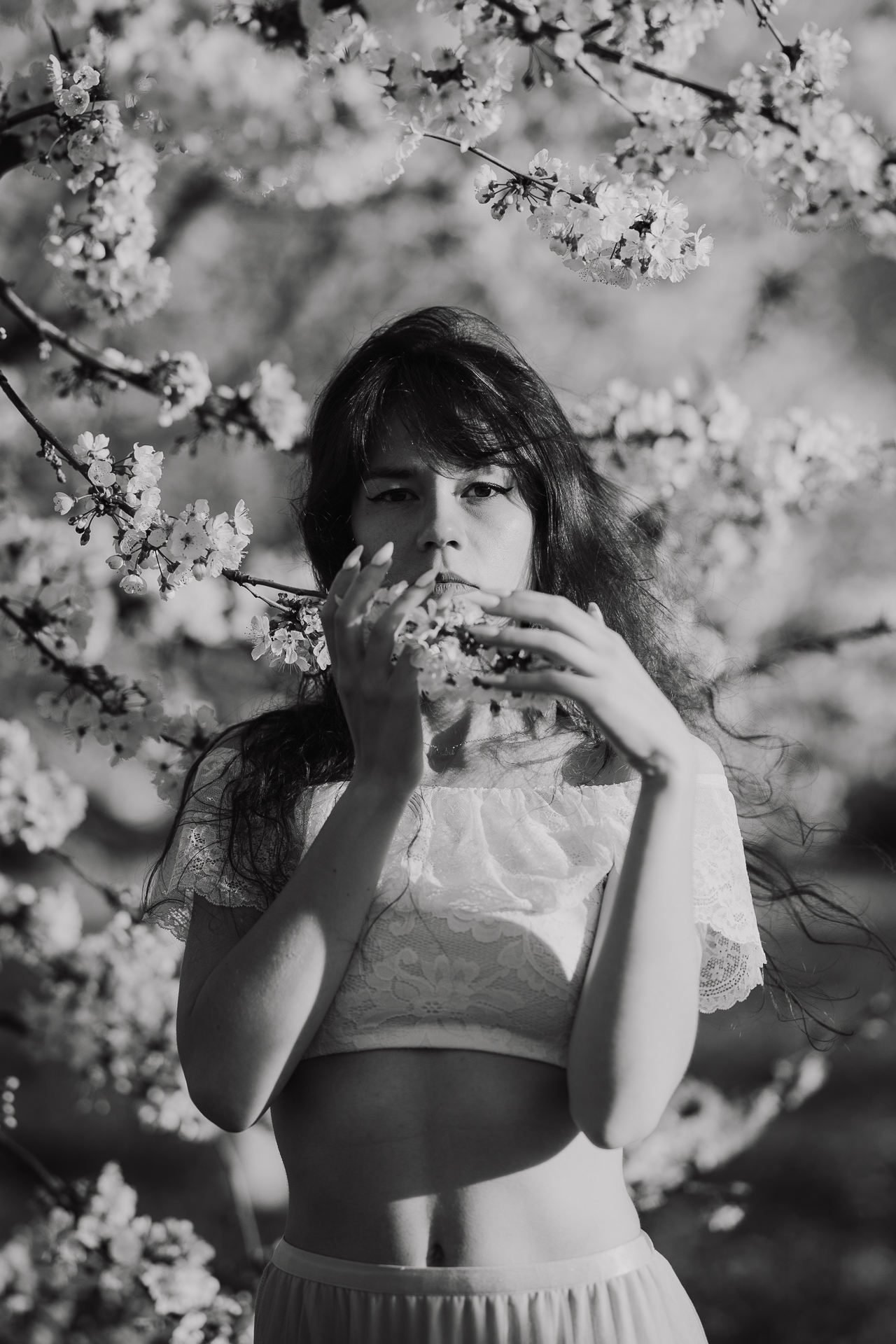 Portret modelki podczas sesji w kwitnącym sadzie jabłoniowym, profesjonalna fotografia kobieca, okolice Krakowa