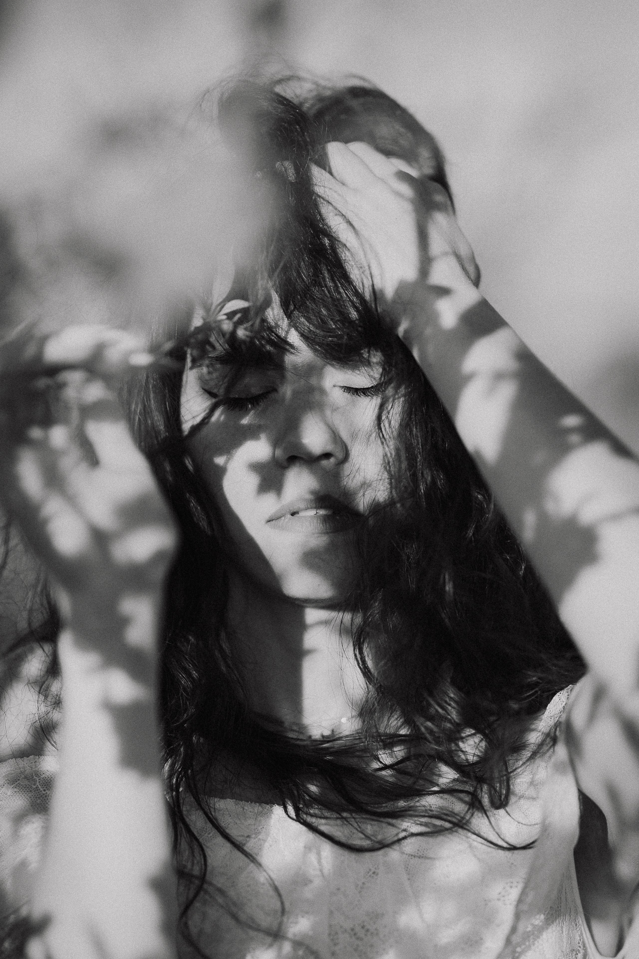 Czarno-biały portret kobiecy w kwitnącym sadzie pod Krakowem, modelka wśród brzoskwini w pełnym rozkwicie, wiosenna sesja fotograficzna