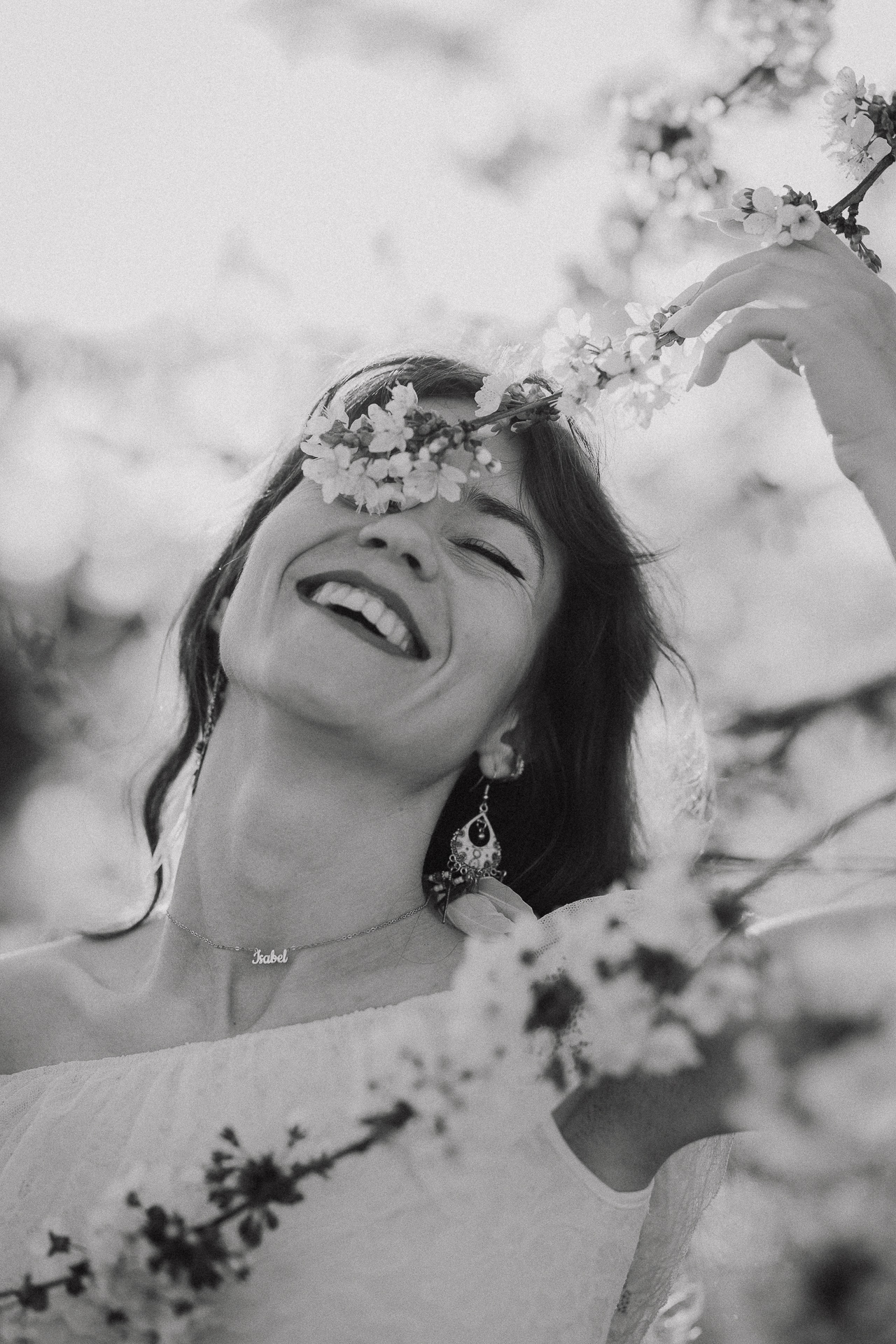 uśmiechnięta kobieta w sadzie owocowym, wiosenna sesja kobieca