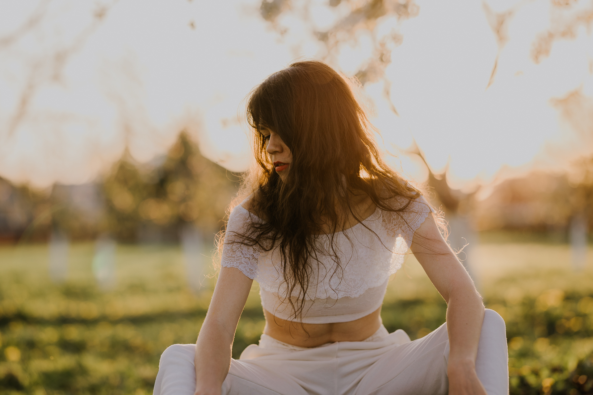 Portret kobiecy w kwitnącym sadzie pod Krakowem, modelka wśród jabłoni w pełnym rozkwicie, wiosenna sesja fotograficzna