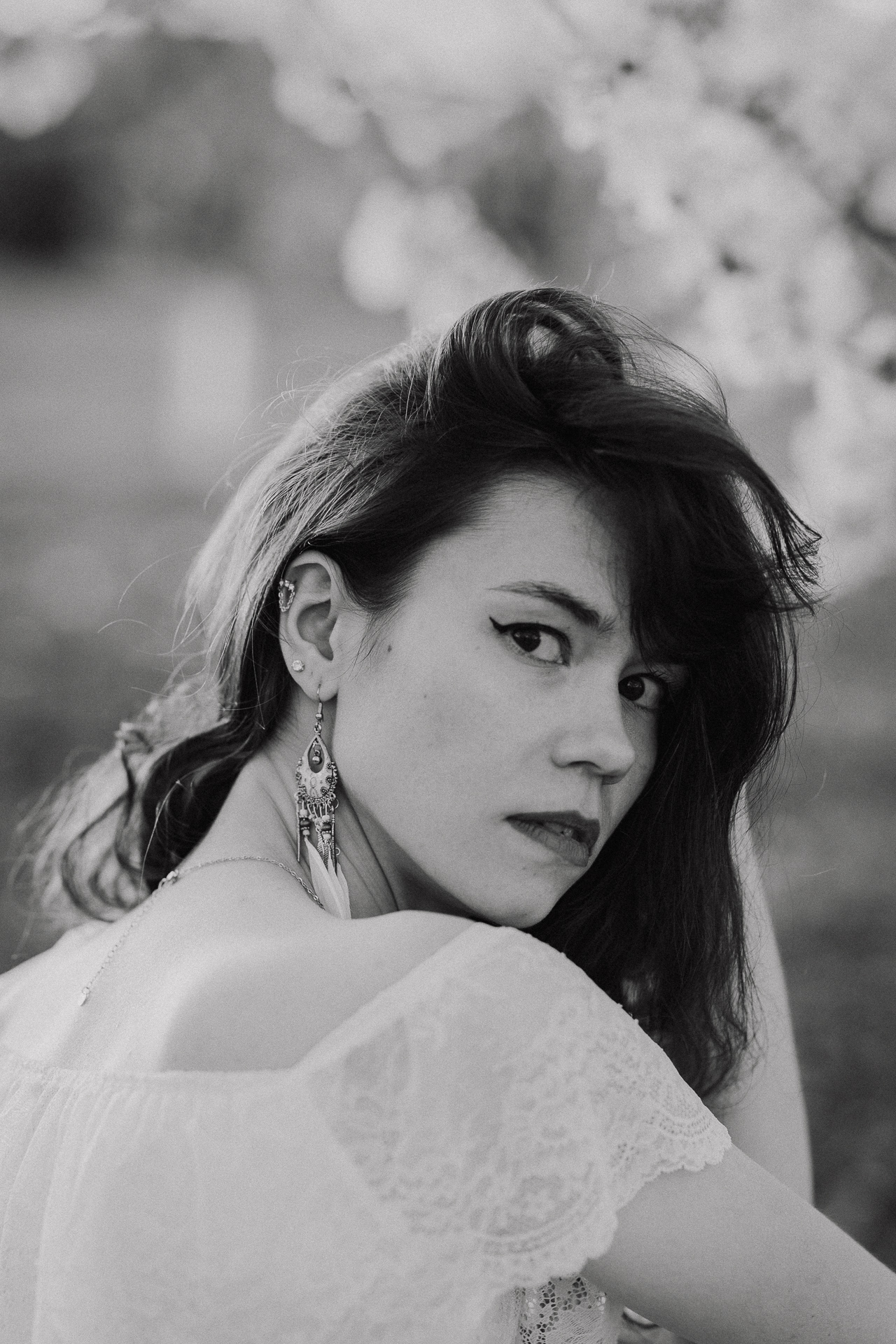 Portret kobiecy w kwitnącym sadzie podczas zachodzącego słońca pod Krakowem, modelka wśród jabłoni w pełnym rozkwicie, wiosenna sesja fotograficzna