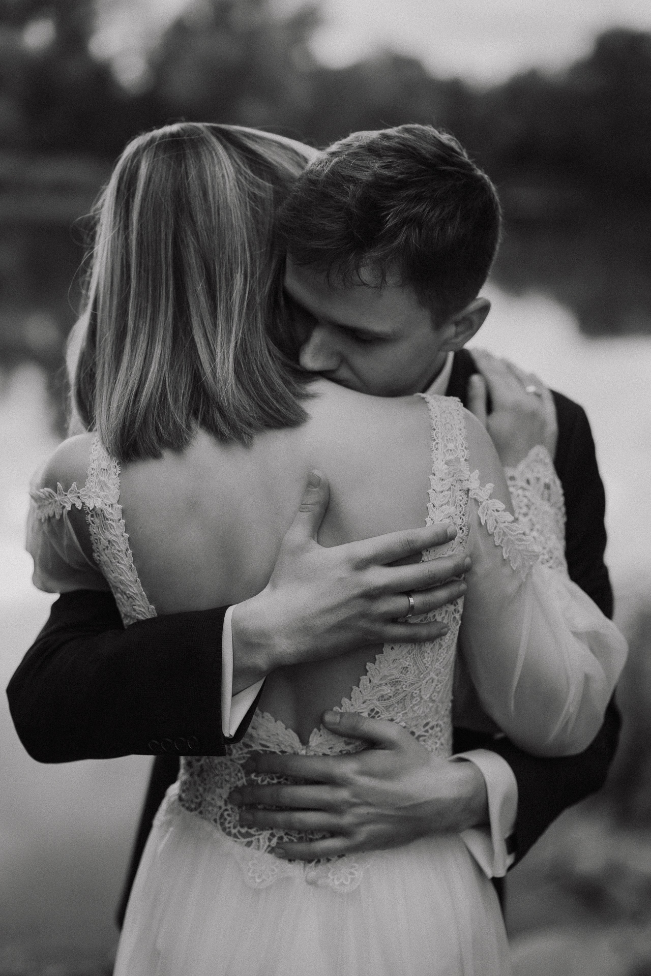 Para Młoda przytula się na tle jeziora w Przylasku Rusieckim