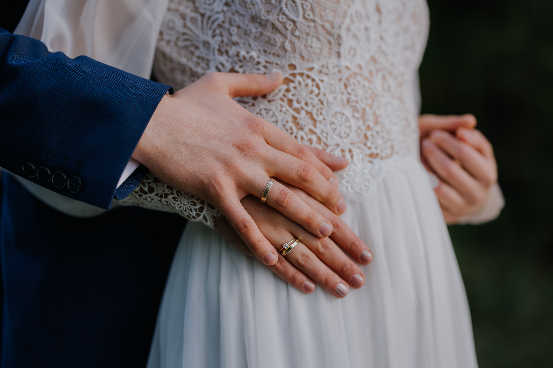 Pan Młody trzyma ręce Panny Młodej podczas sesji poślubnej