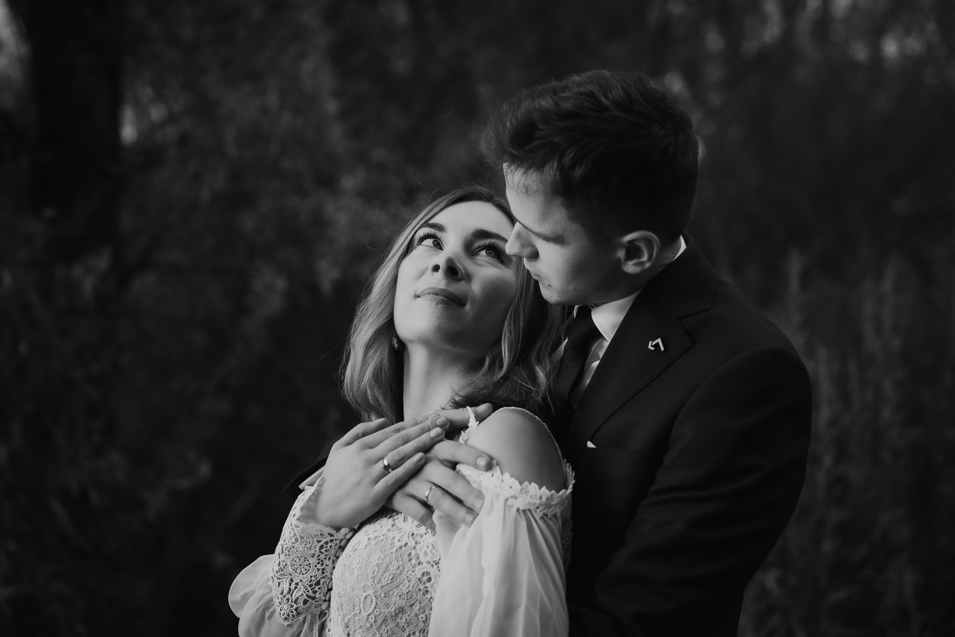 Pan Młody przytula Pannę Młodą podczas sesji poślubnej