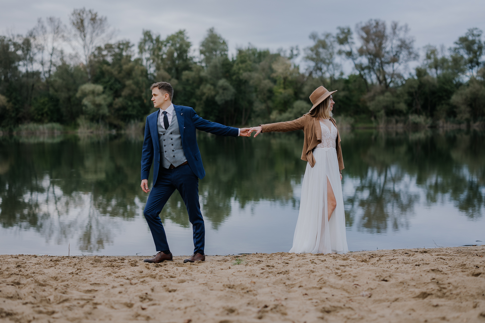 Para Młoda trzyma się za ręce podczas sesji poślubnej