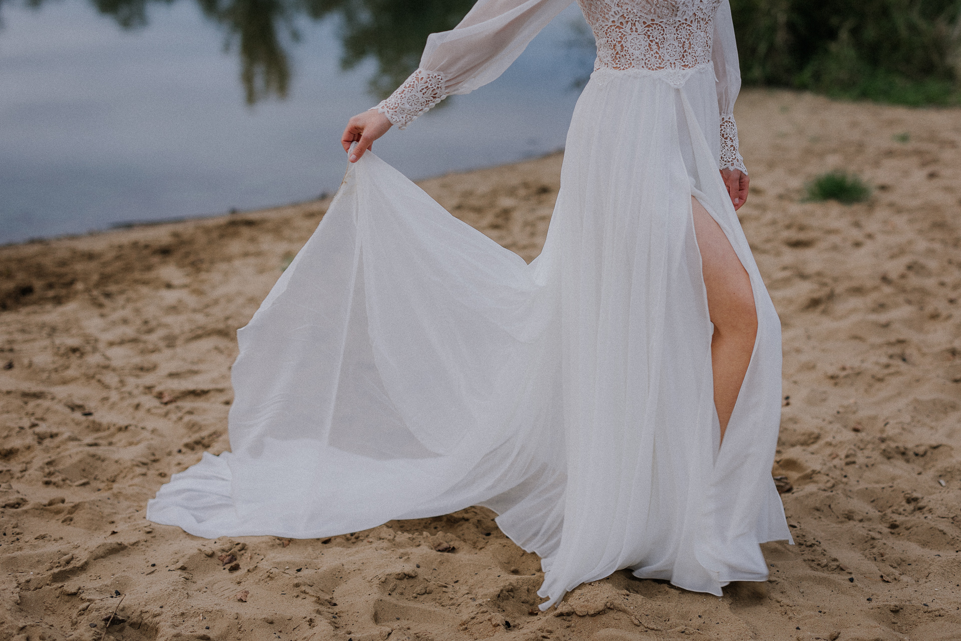 panna młoda trzyma suknię podczas sesji poślubnej