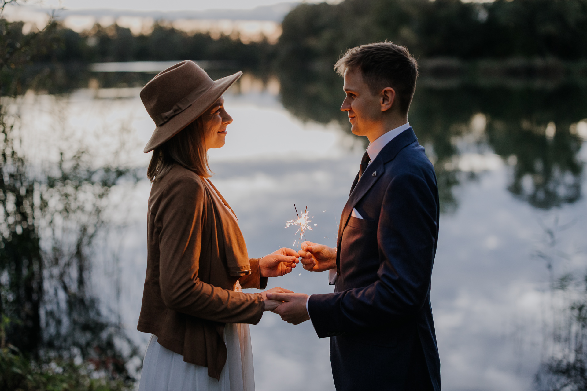 Para Młoda trzyma zimne ognie i patrzy sobie w oczy