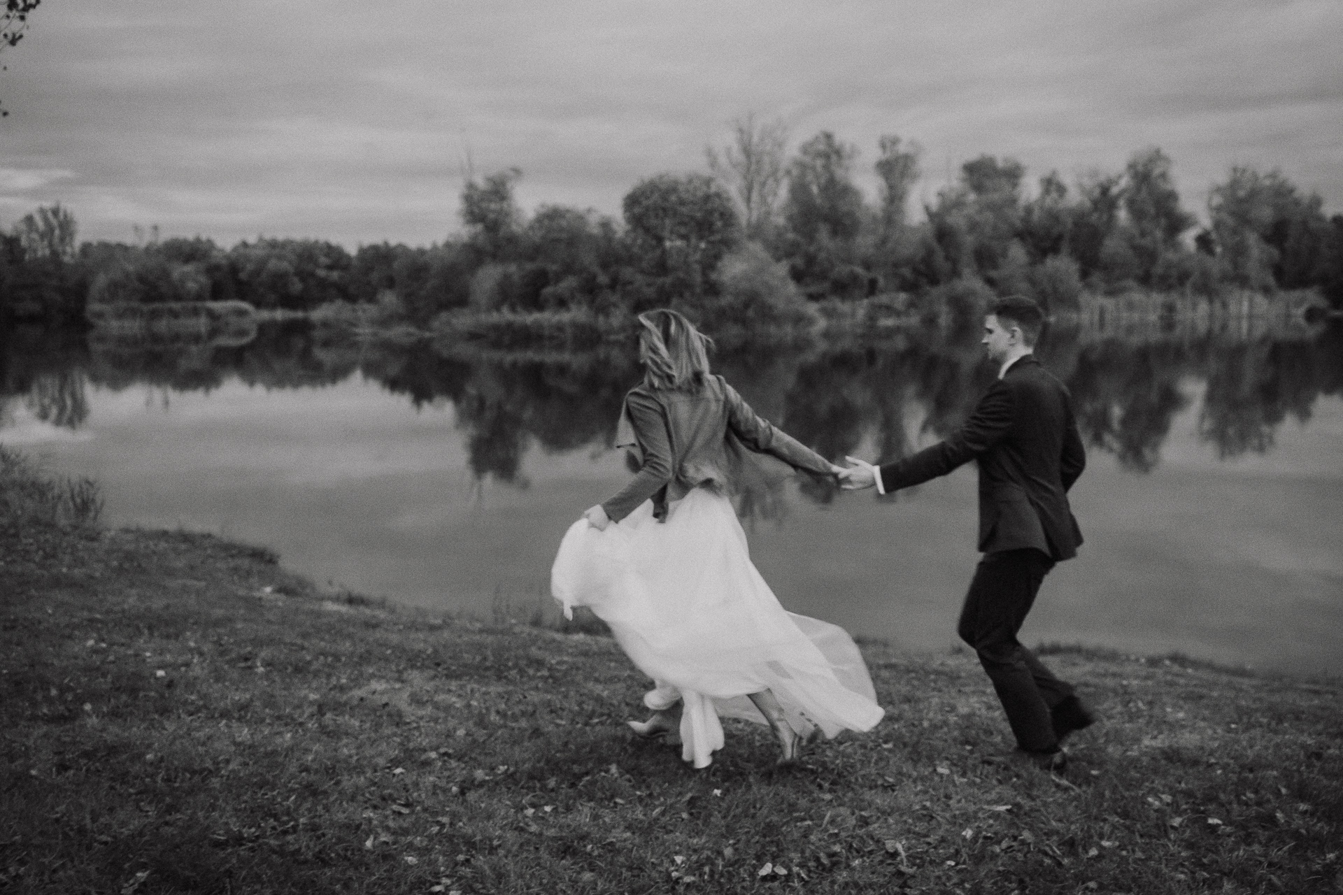 Para młoda biegnie na tle stawu w przylasku rusieckim