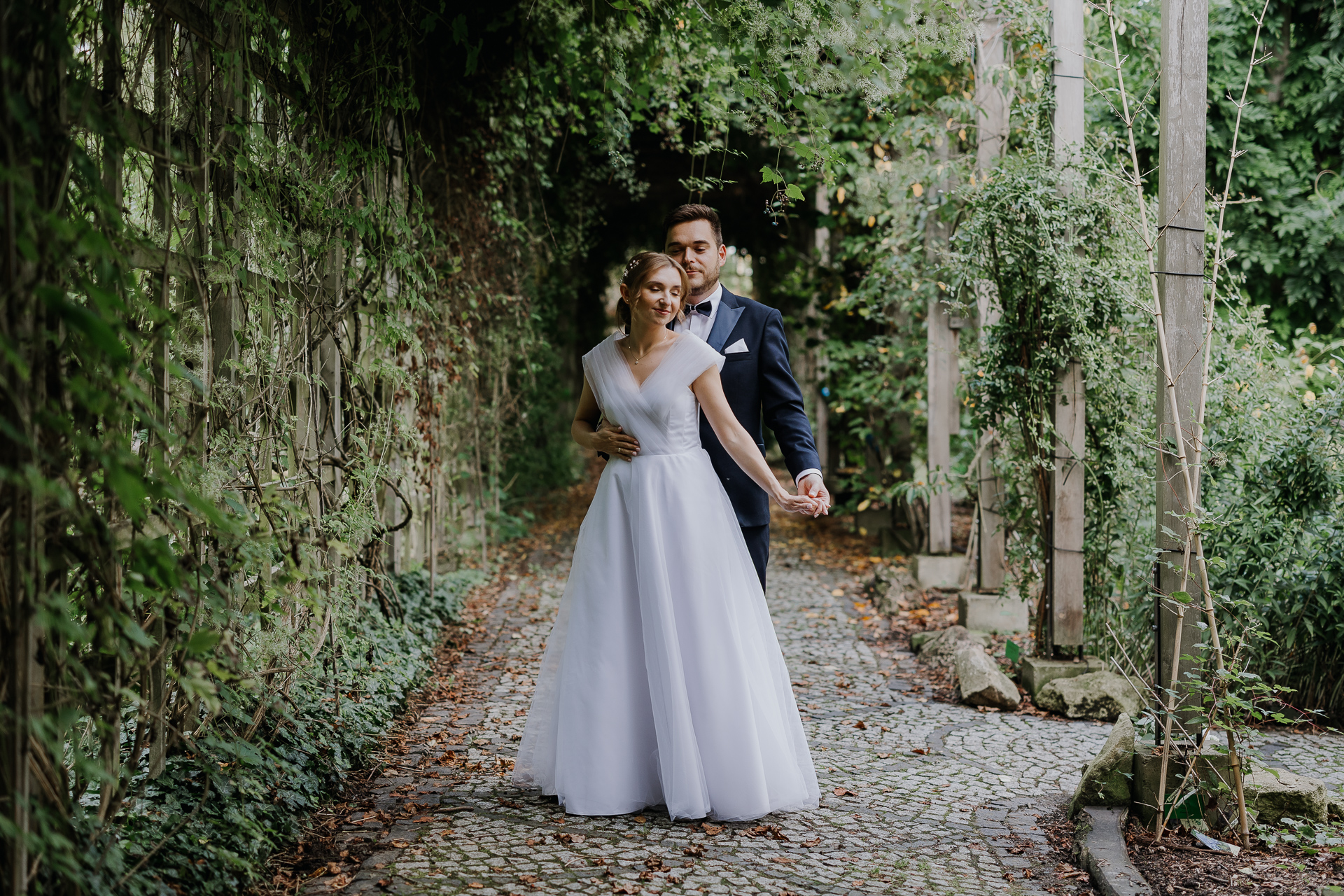 Para młoda tańczy podczas sesji poślubnej w arboretum Bolestraszyce, romantyczne ujęcie wśród egzotycznych roślin, fotografia ślubna Podkarpacie
