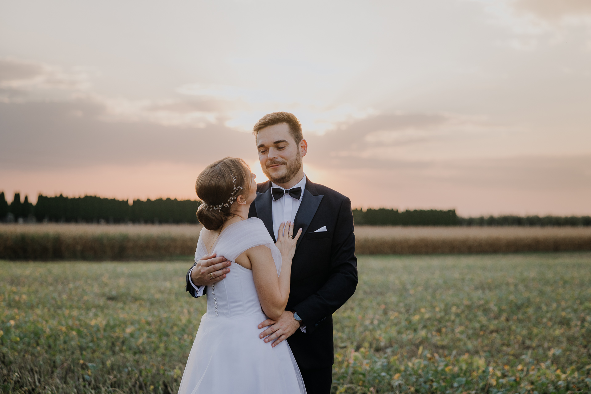 Para młoda w promieniach zachodzącego słońca przy Willi Bolestraszyce, wieczorna sesja poślubna w arboretum, Podkarpacie