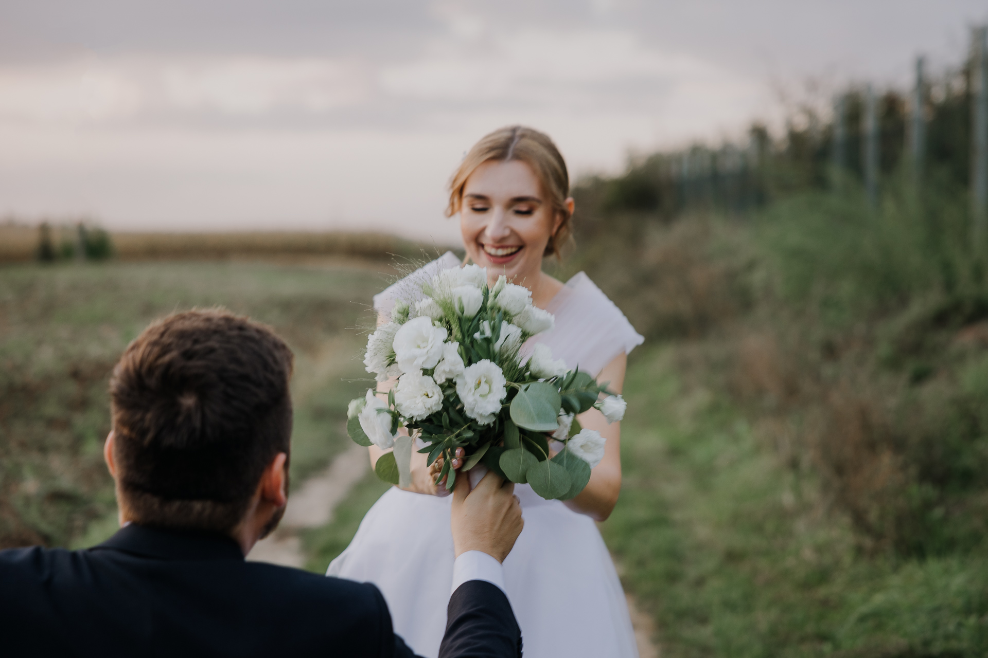 Pan Młody daje bukiet kwiatów Pannie Młodej na sesji poślubnej przy Willi Bolestraszyce, Przemyśl, Podkarpacie