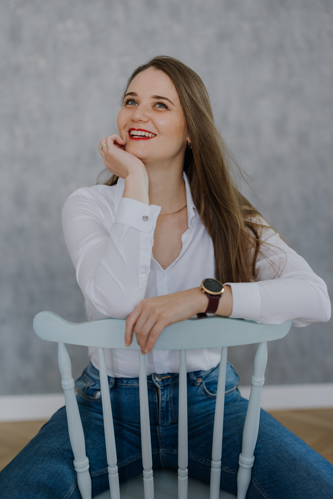 kobieta siedzi na krześle i uśmiecha się podczas sesji wizerunkowej