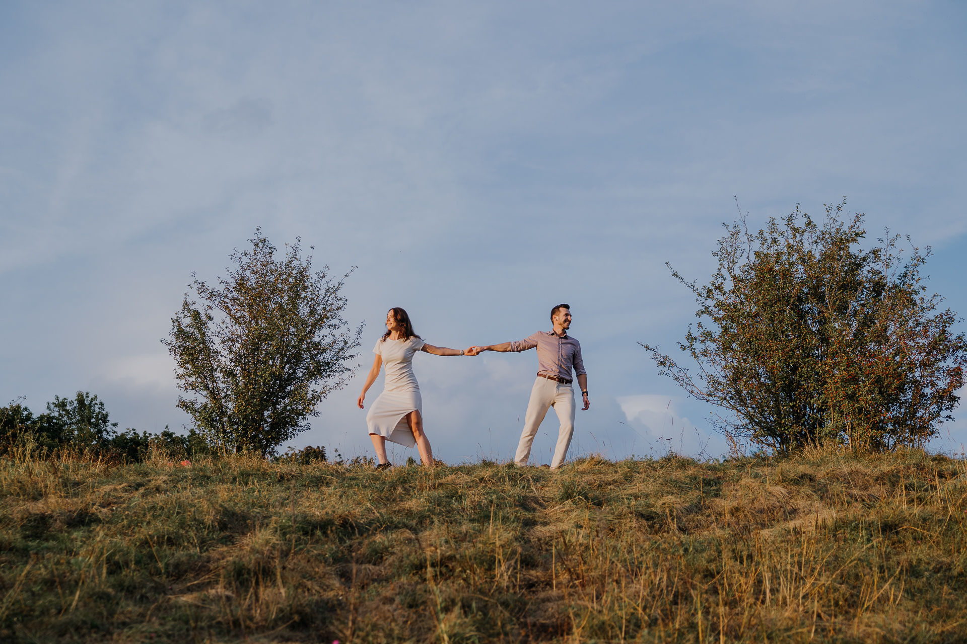 para narzeczonych stoi obok siebie na tle niebieskiego nieba