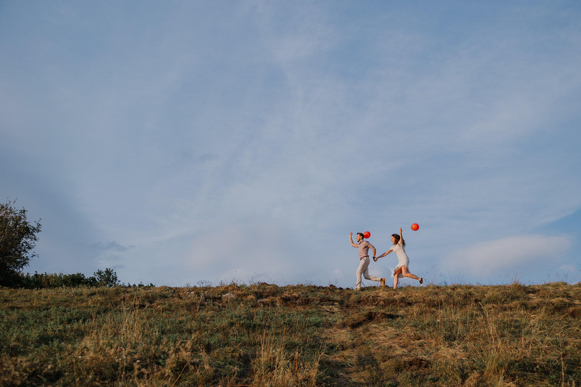 para narzeczonych biegnie z balonami na sesji zdjęciowej w Krakowie