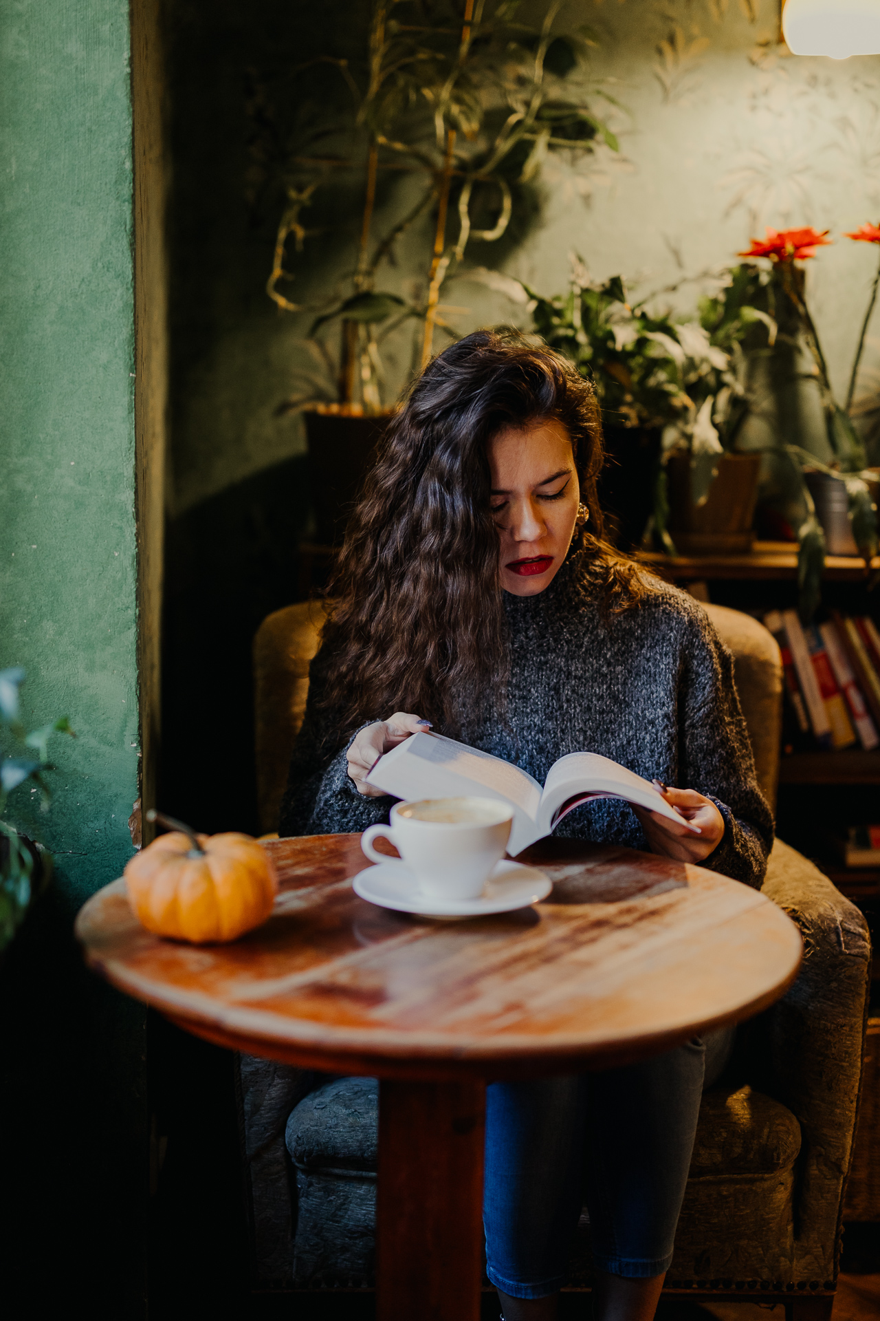 kobieta czyta książkę w kawiarni Massolit w Krakowie