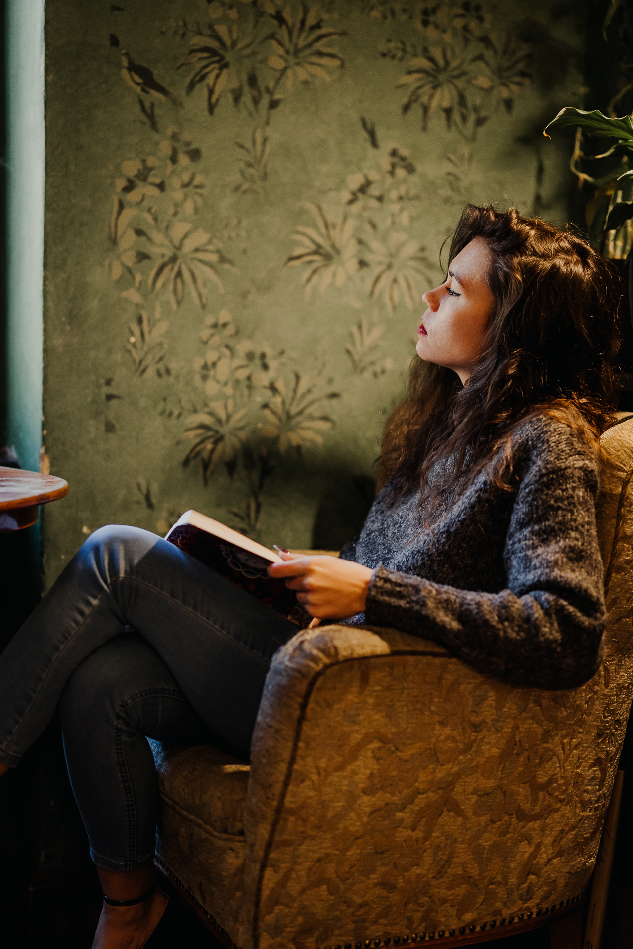 kobieta czyta książkę w kawiarni Massolit w Krakowie