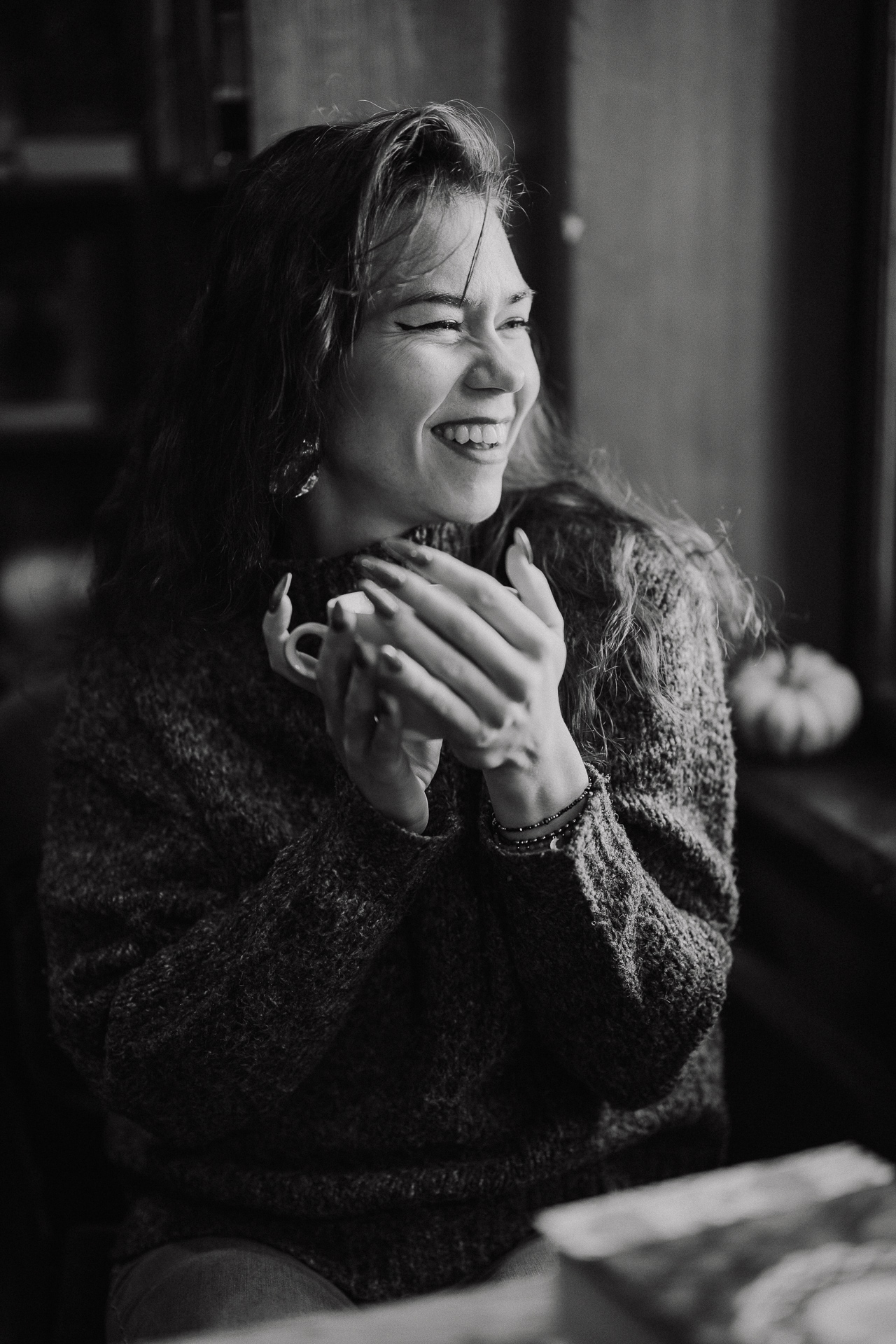 Uśmiechnięta kobieta pije kawę w kawiarni Massolit w Krakowie