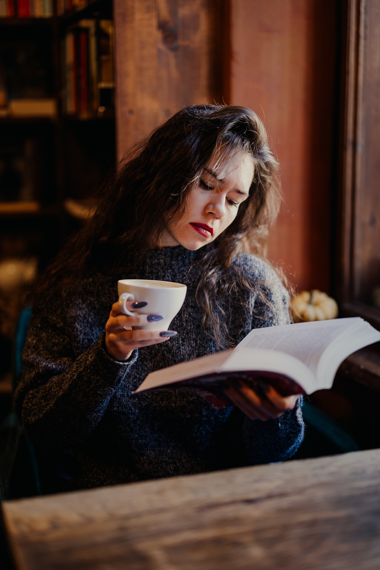 kobieta pije kawę i czyta książkę w kawiarni massolit