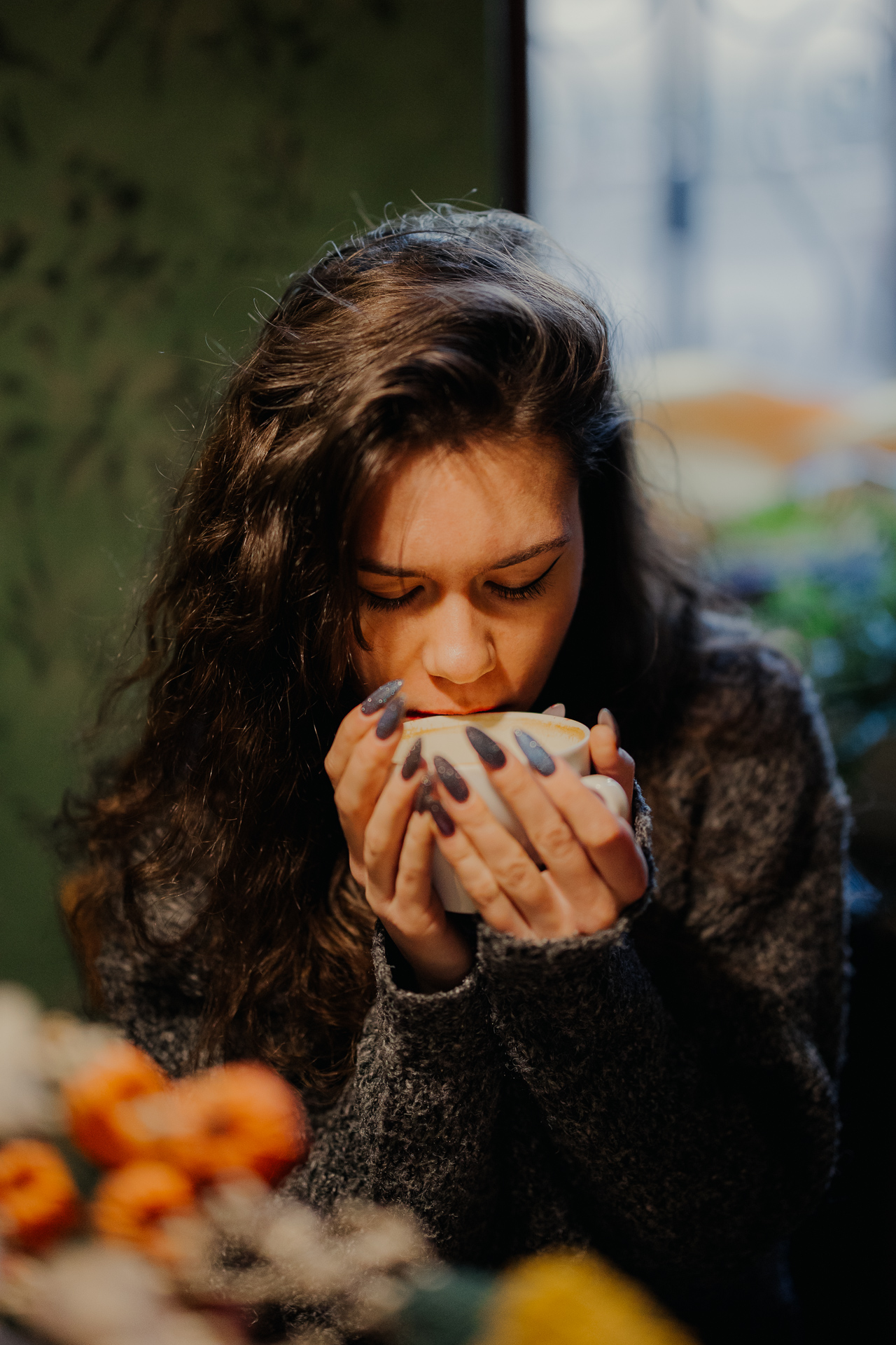 portret kobiety trzymającej kubek z kawą w kawiarni Massolit w Krakowie