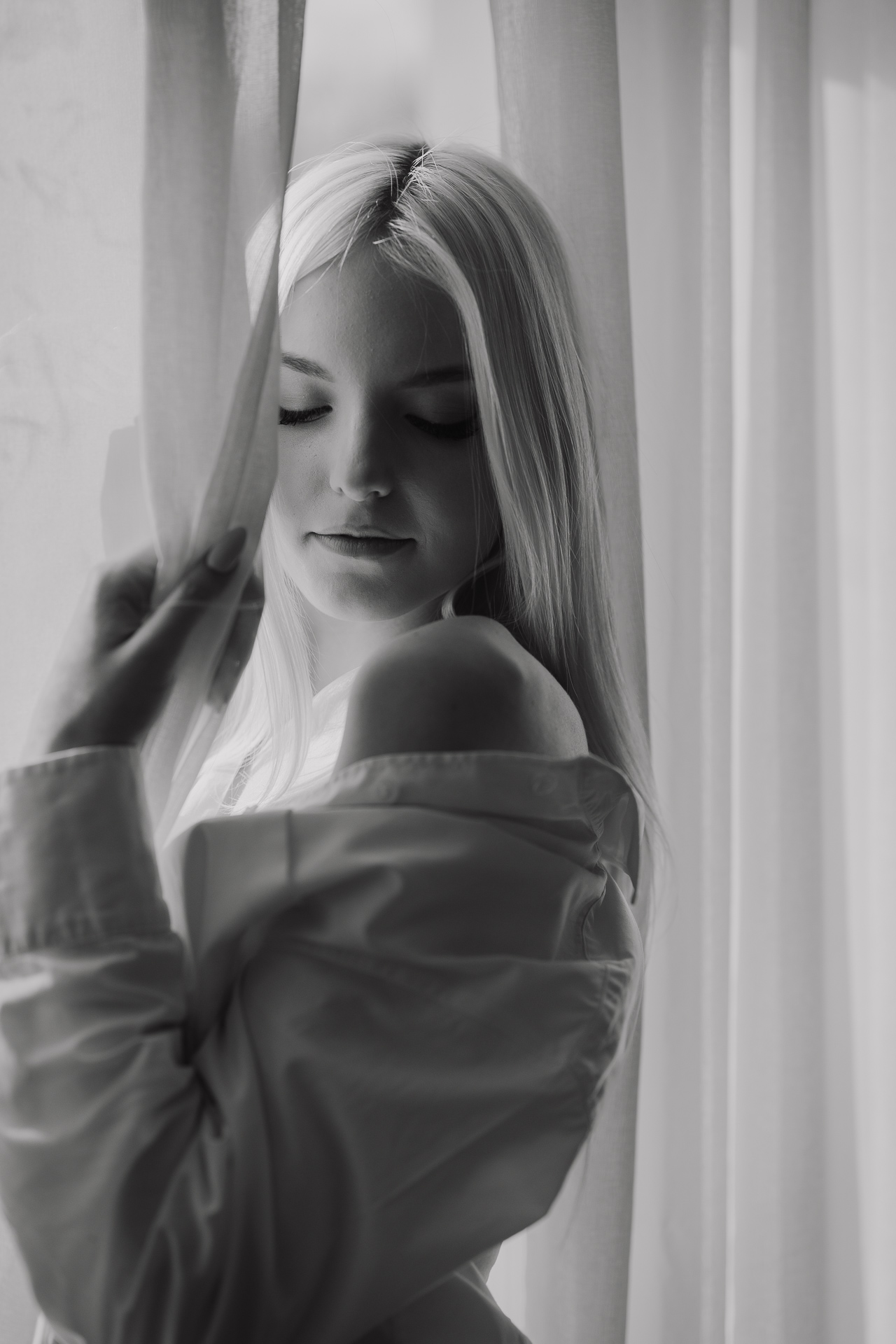 Modelka pozująca przy oknie krakowskiego studia, czarno-biały portret