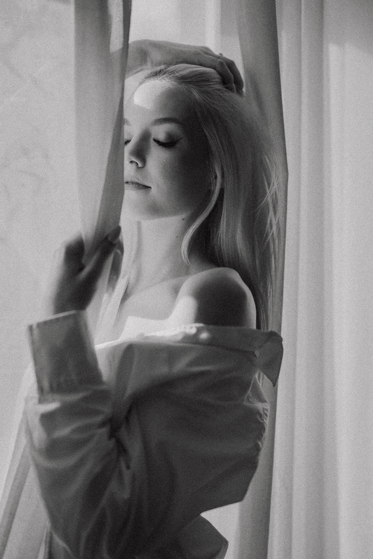 Modelka pozująca przy oknie krakowskiego studia, czarno-biały portret