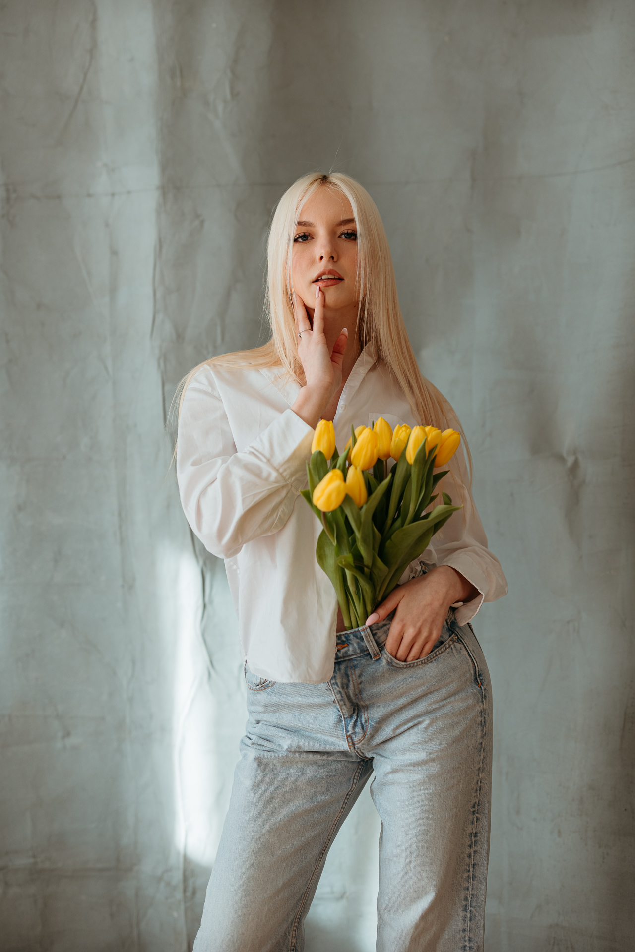 kobieta pozująca z tulipanami w spodniach w krakowskim studio