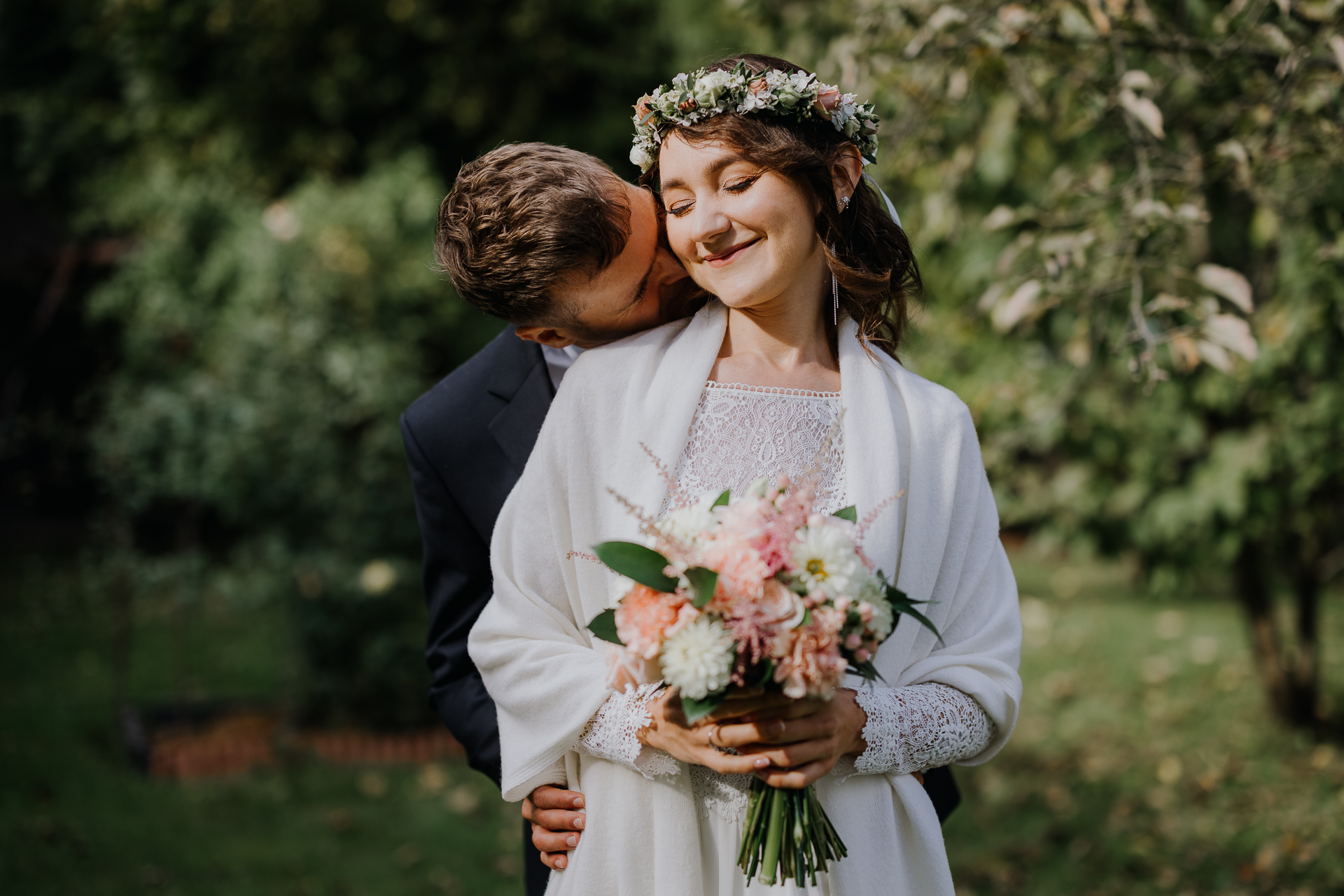 pan młody całuje pannę młodą w szyję w dniu ślubu