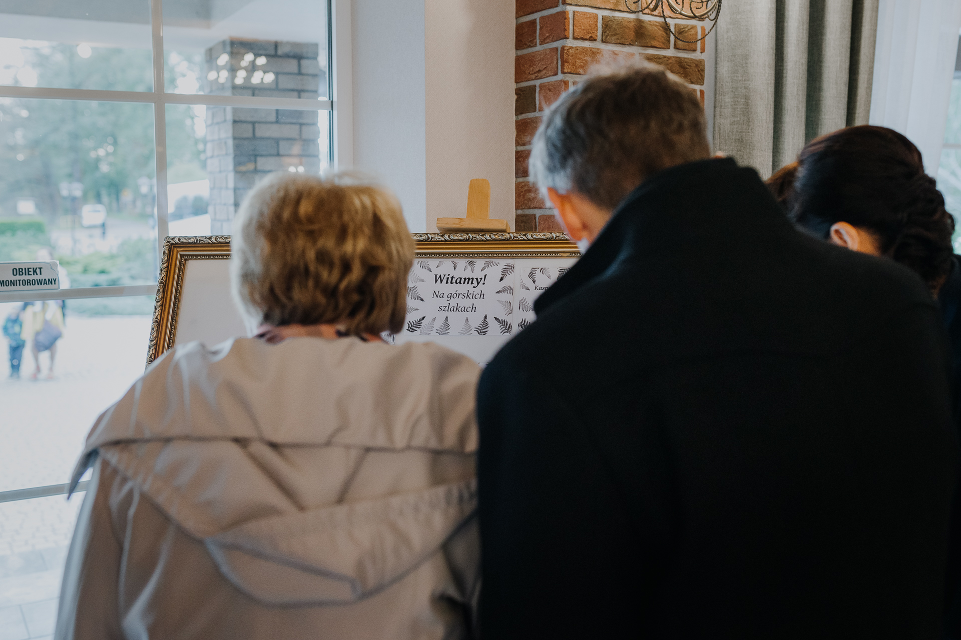 goście weselni sprawdzają gdzie siedzą na sali