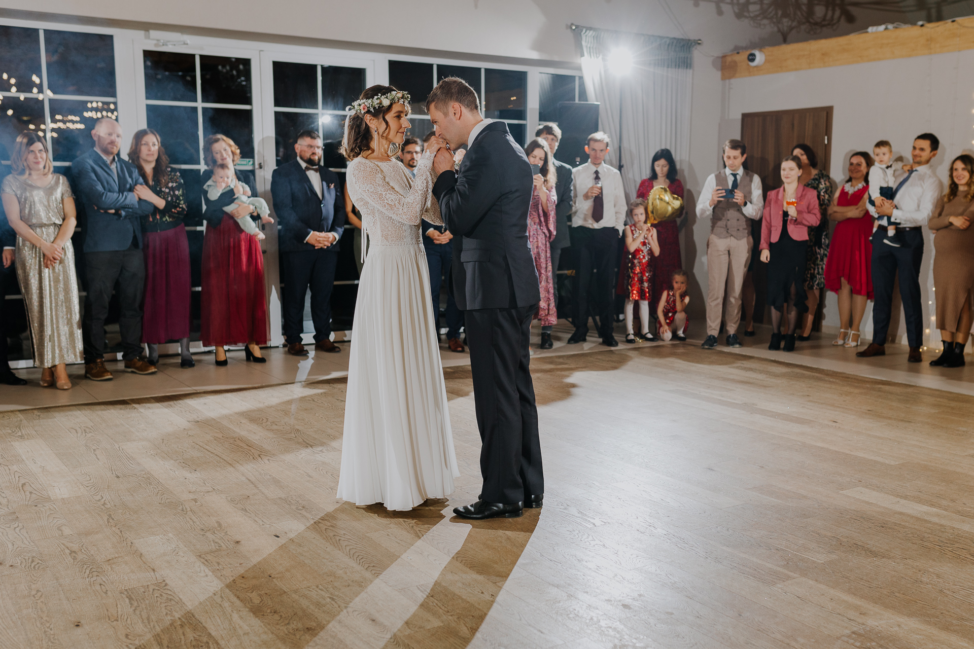 Pan Młody całuje Pannę Młodą w dłonie przed pierwszym tańcem