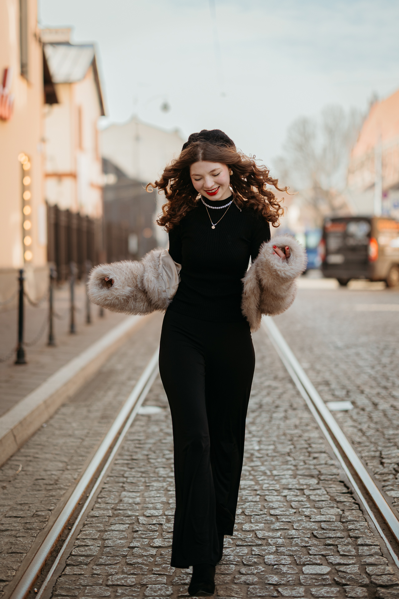 Sesja miejska_Wiktoria-37 Kobieta w stylu paryskim biegnie na ulicy na krakowskim Kazimierzu, klasyczna francuska elegancja na tle miejskiej sztuki