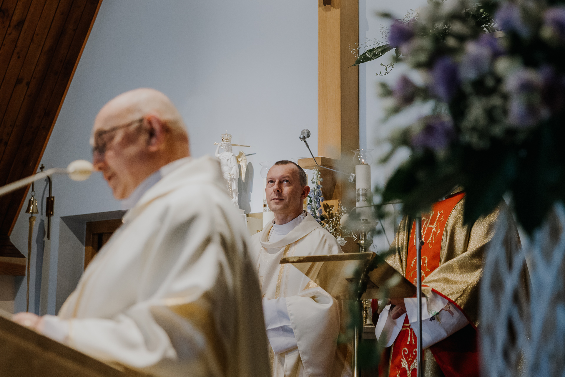 ksiądz spogląda w górę w kościele