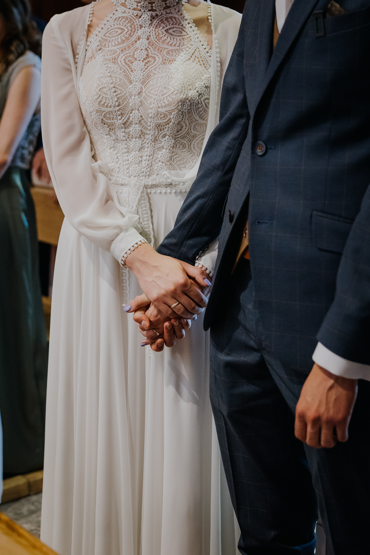 Państwo Młodzi trzymają się za ręce w kościele