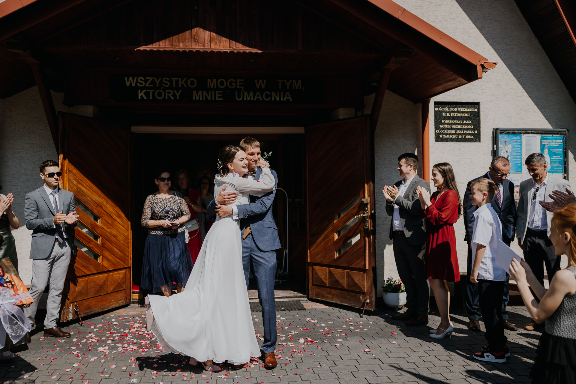 Państwo Młodzi przytuleni pod kościołem w Jaroszówce