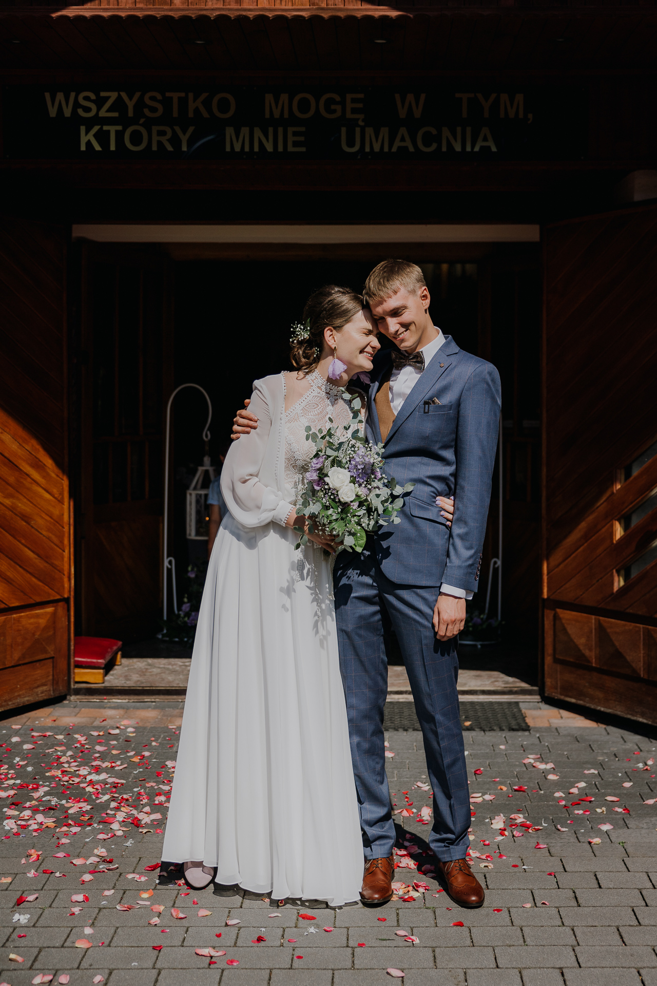 Państwo Młodzi przytuleni pod kościołem