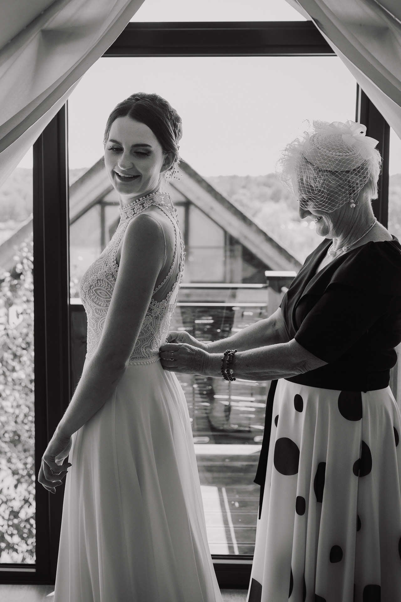 Mama Panny Młodej zapina suknię ślubną