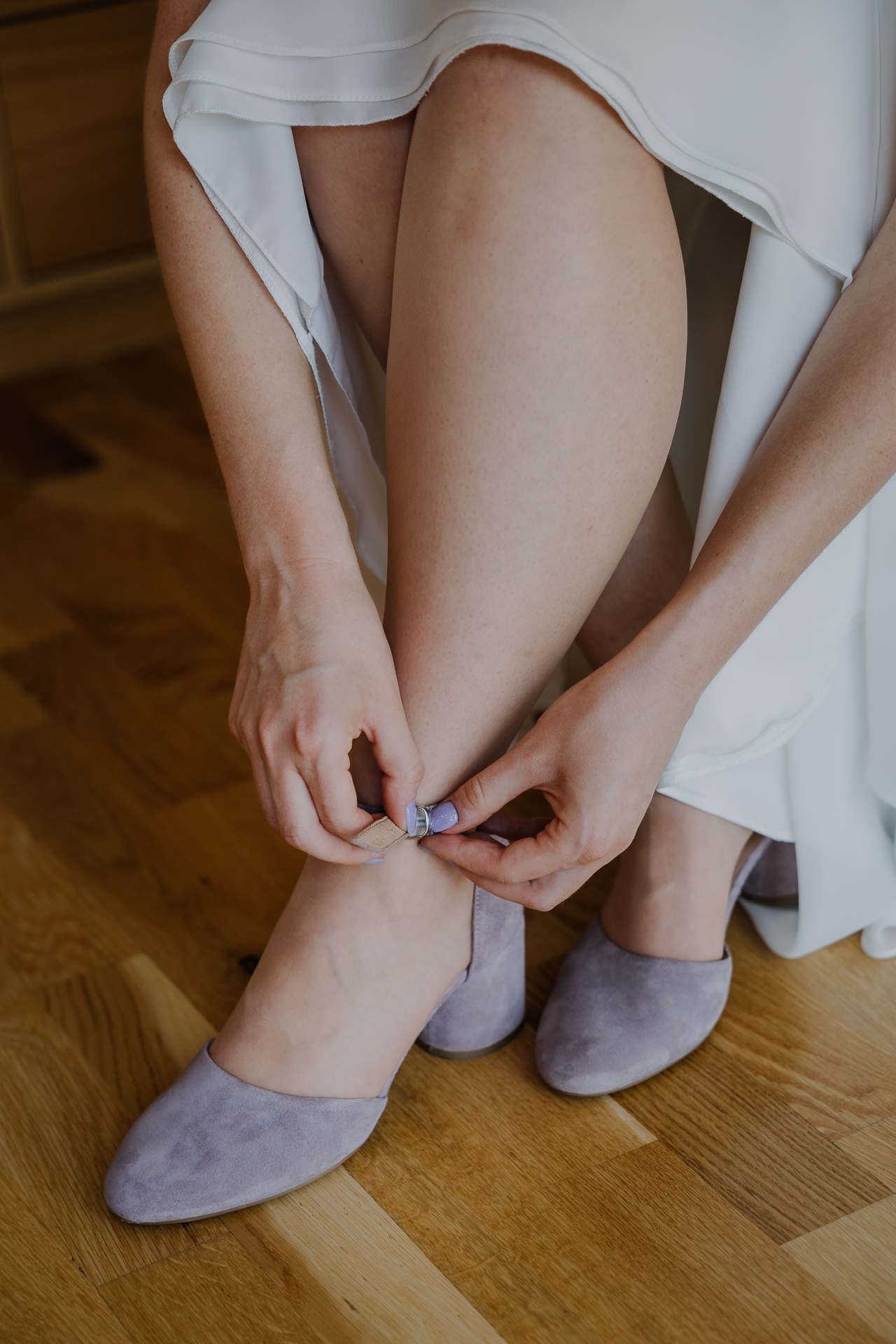 Panna Młoda zapina buty ślubne podczas przygotowań
