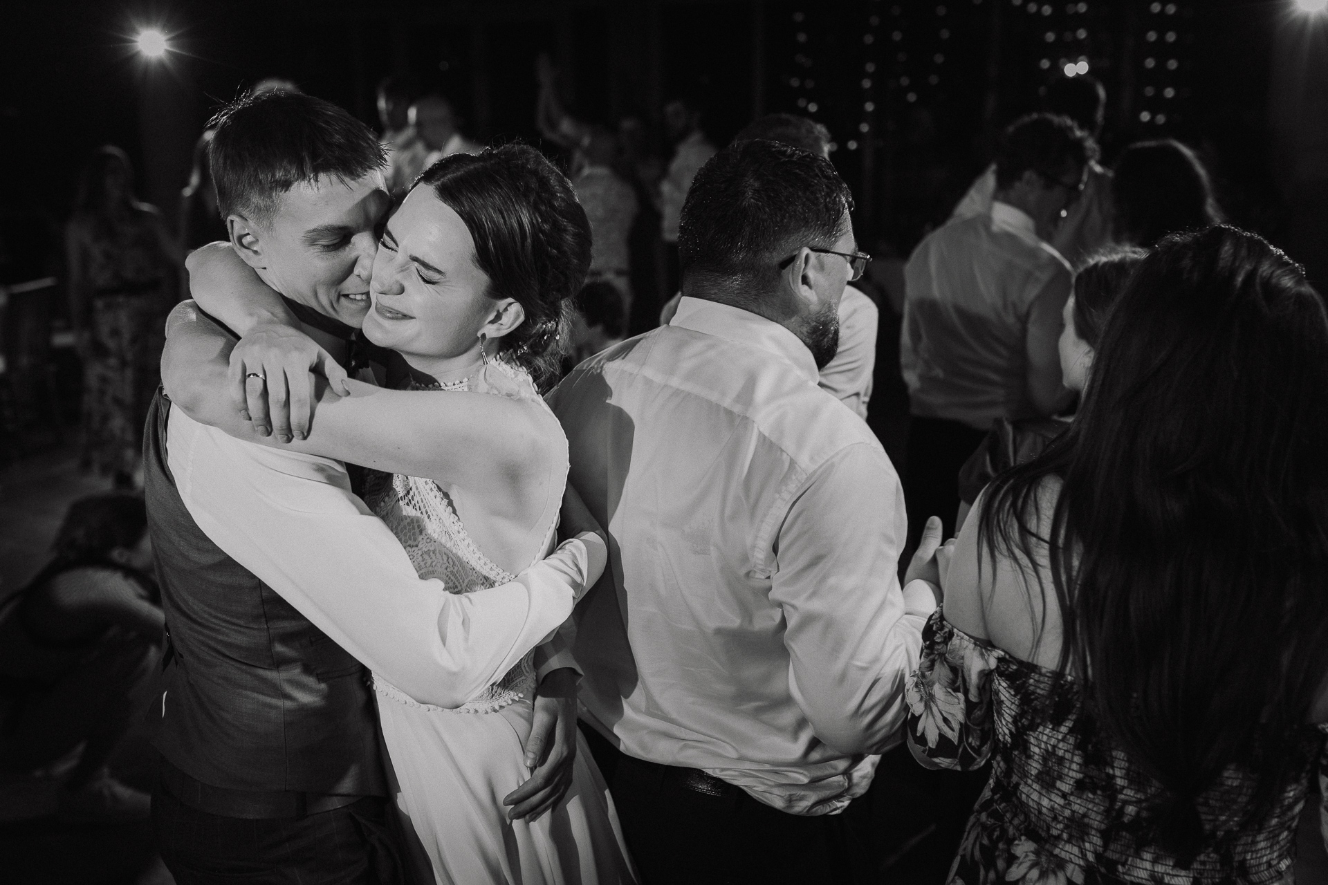 Państwo Młodzi przytulają się na sali weselnej