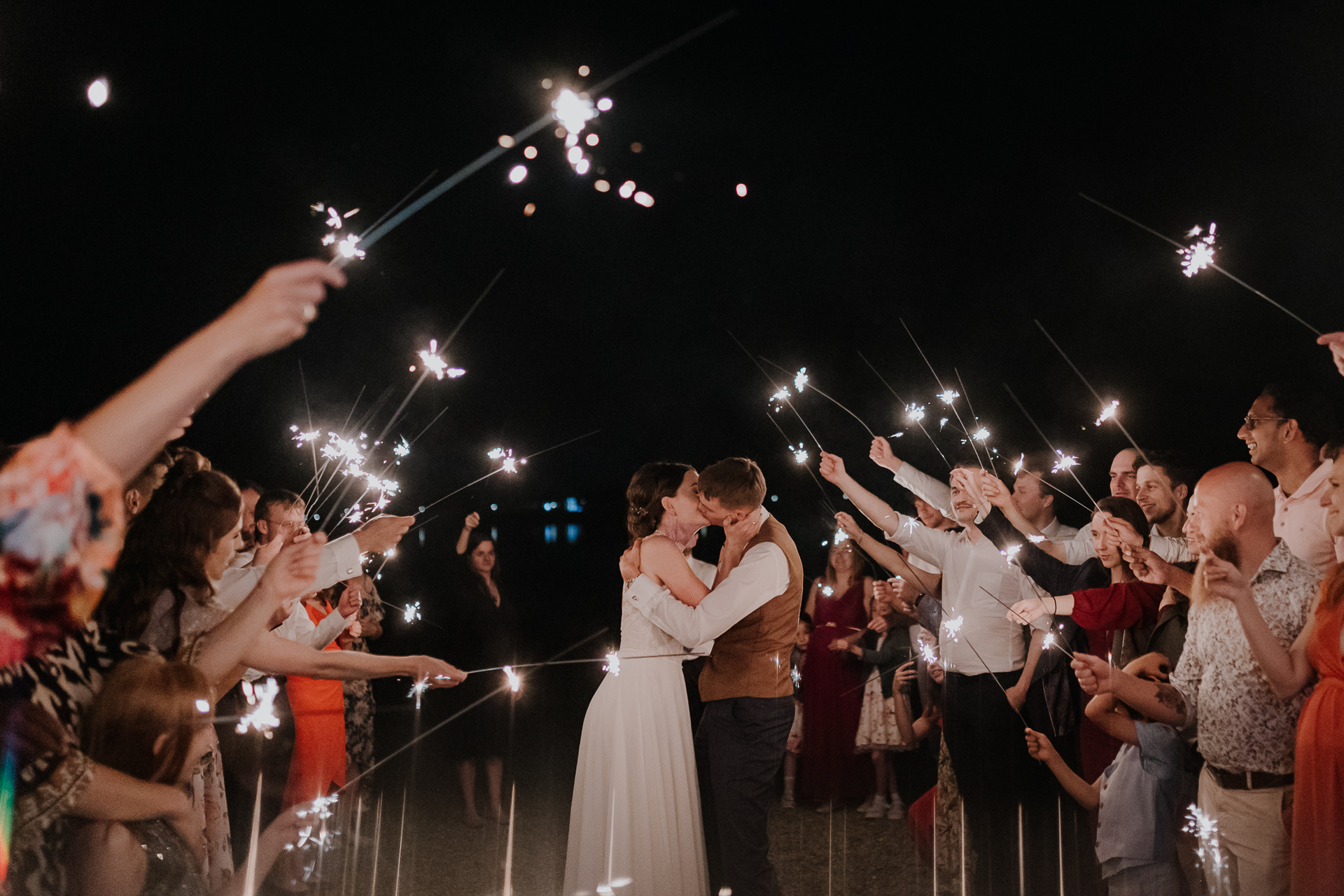 Państwo Młodzi całują się przy zimnych ogniach