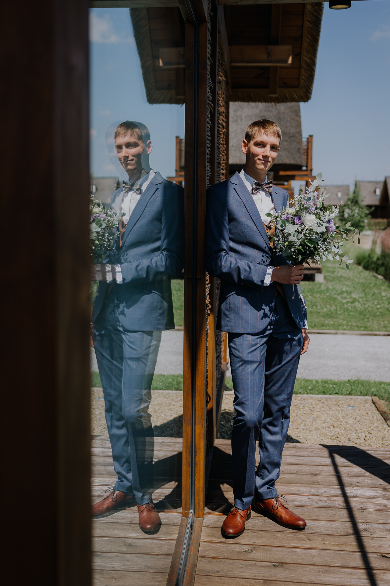 Pan Młody z bukietem ślubnym przed first lookiem