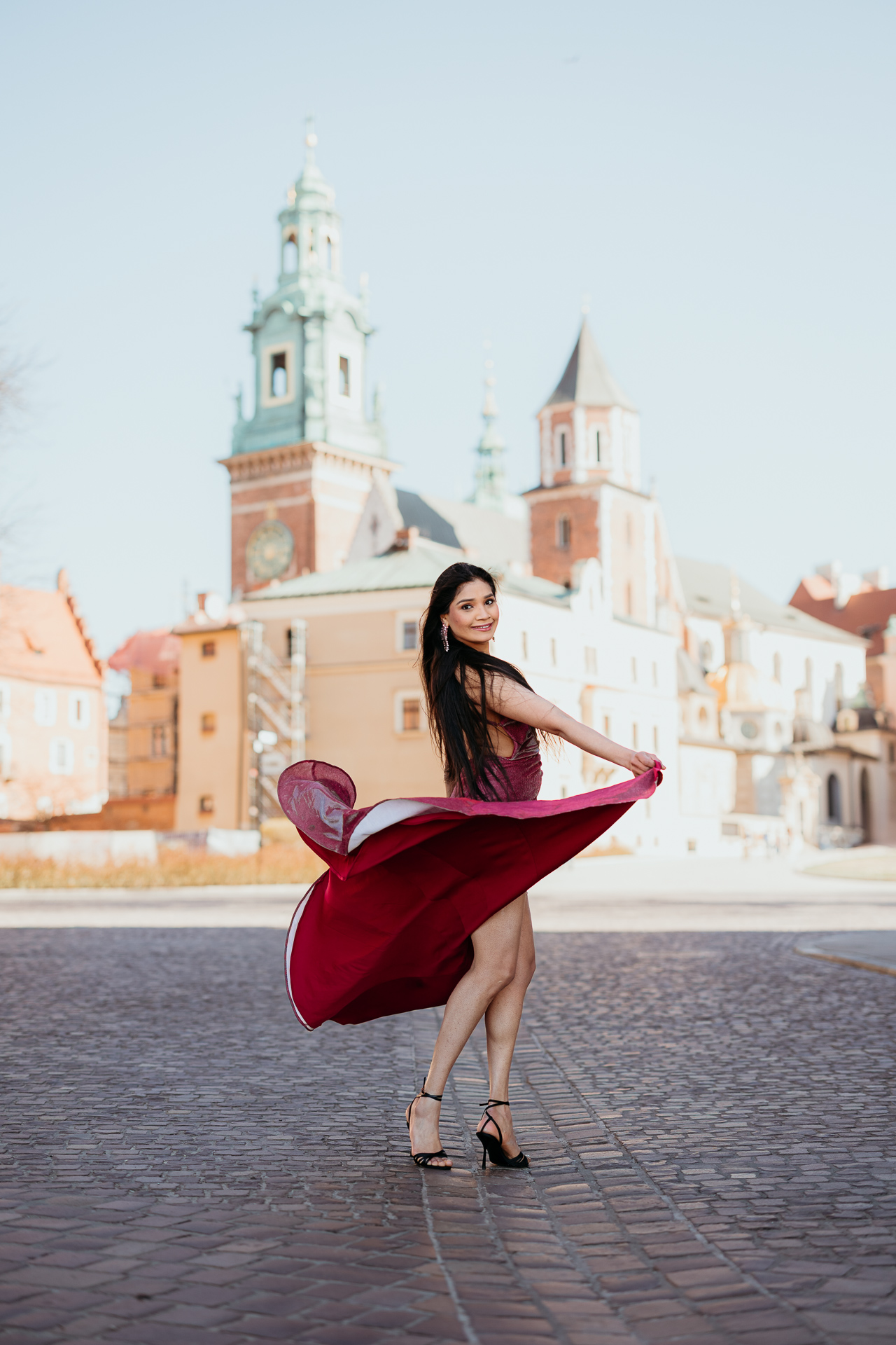 Sesja kobieca na Wawelu_Divya-25 Modelka w wiśniowej sukni pozuje na tle Wawelu, sesja na Wawelu