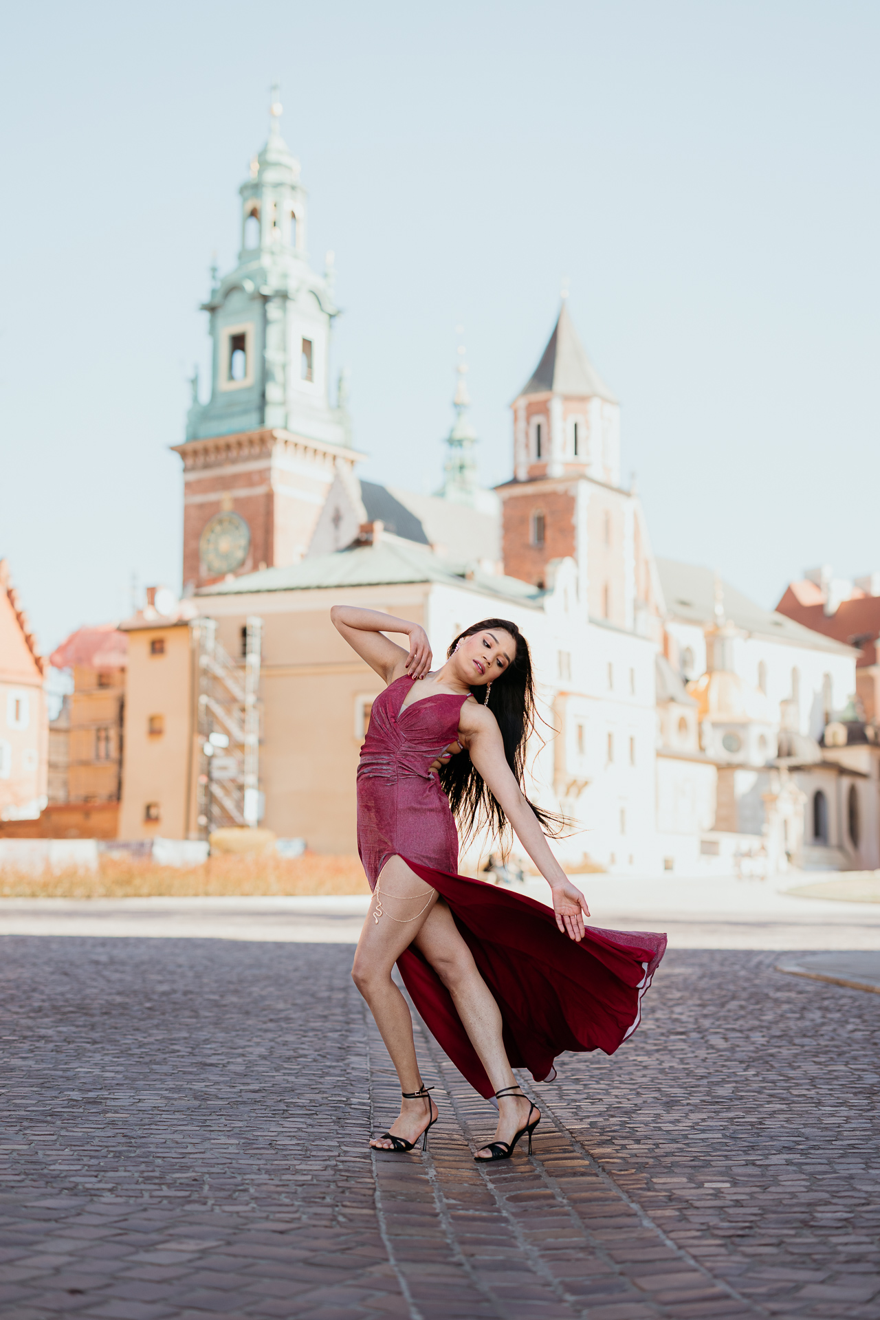 Sesja kobieca na Wawelu_Divya-26 Modelka w wiśniowej sukni pozuje na tle Wawelu, sesja na Wawelu