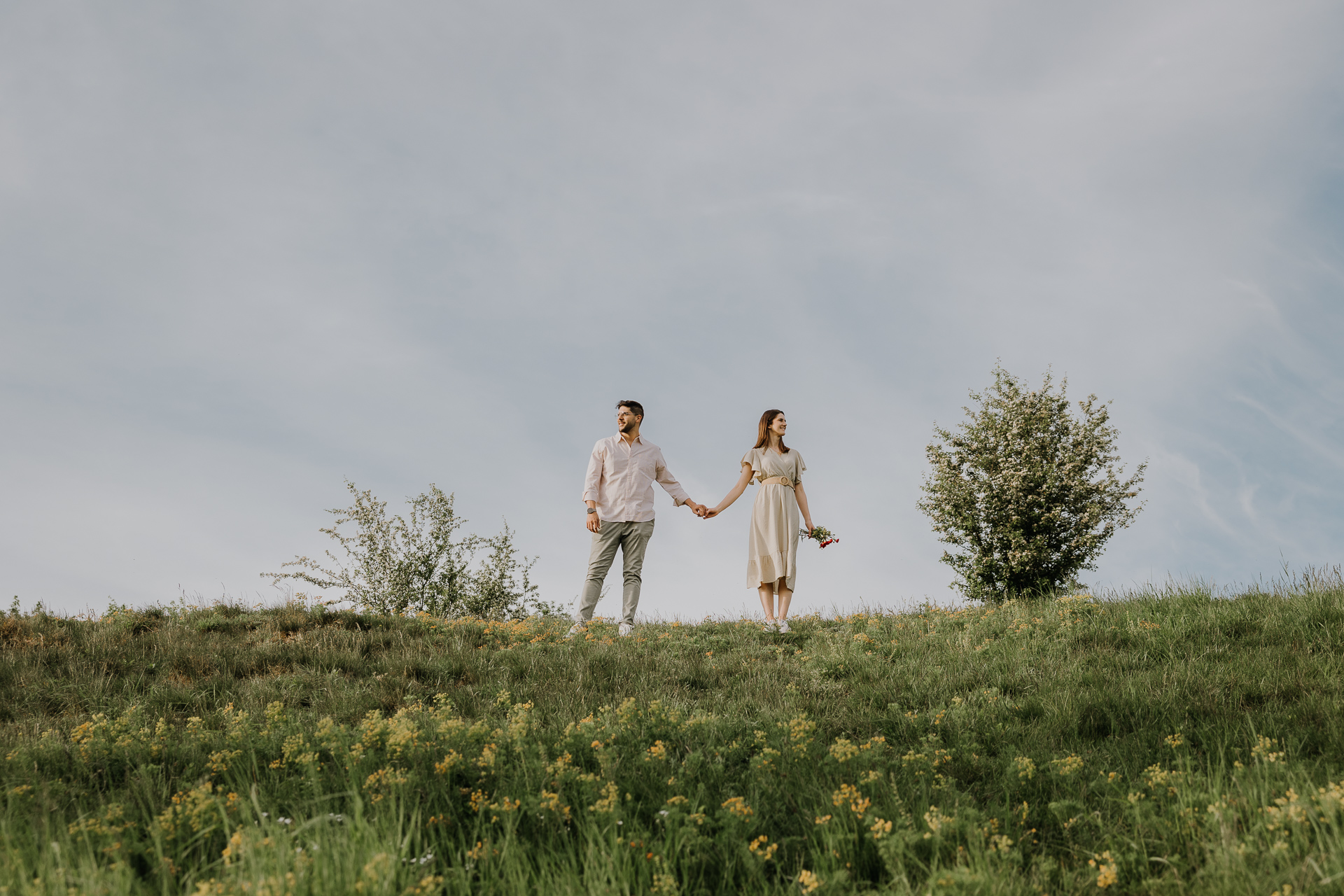 Para narzeczonych stoi na górce i trzyma się za ręce