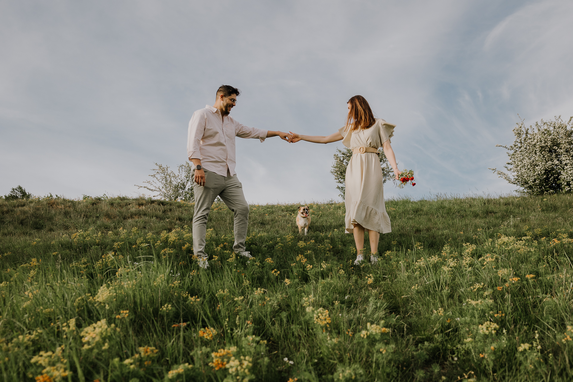 Para narzeczonych z pieskiem pozują na sesji zdjęciowej