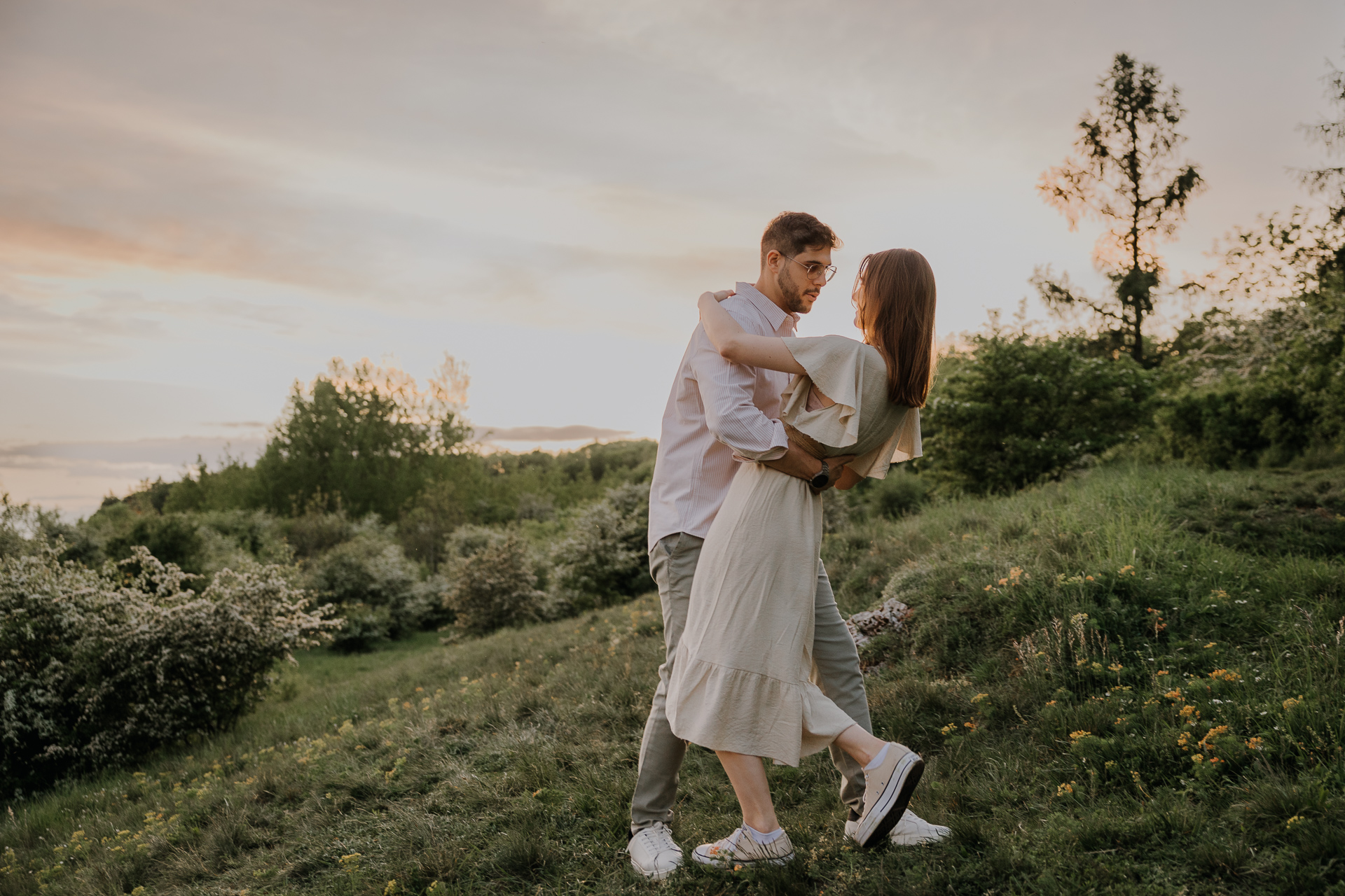 Para narzeczonych tańczy w złotej godzinie podczas sesji narzeczeńskiej