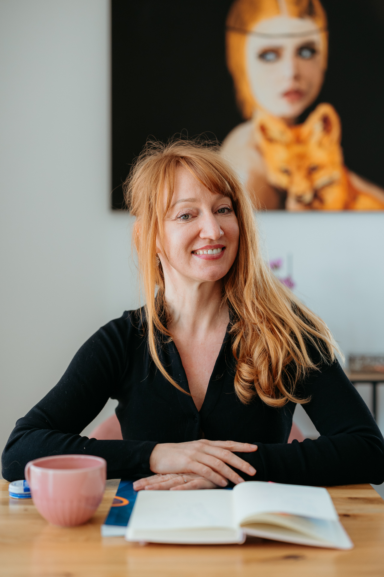 kobieta siedzi przy laptopie i się uśmiecha podczas sesji wizerunkowej