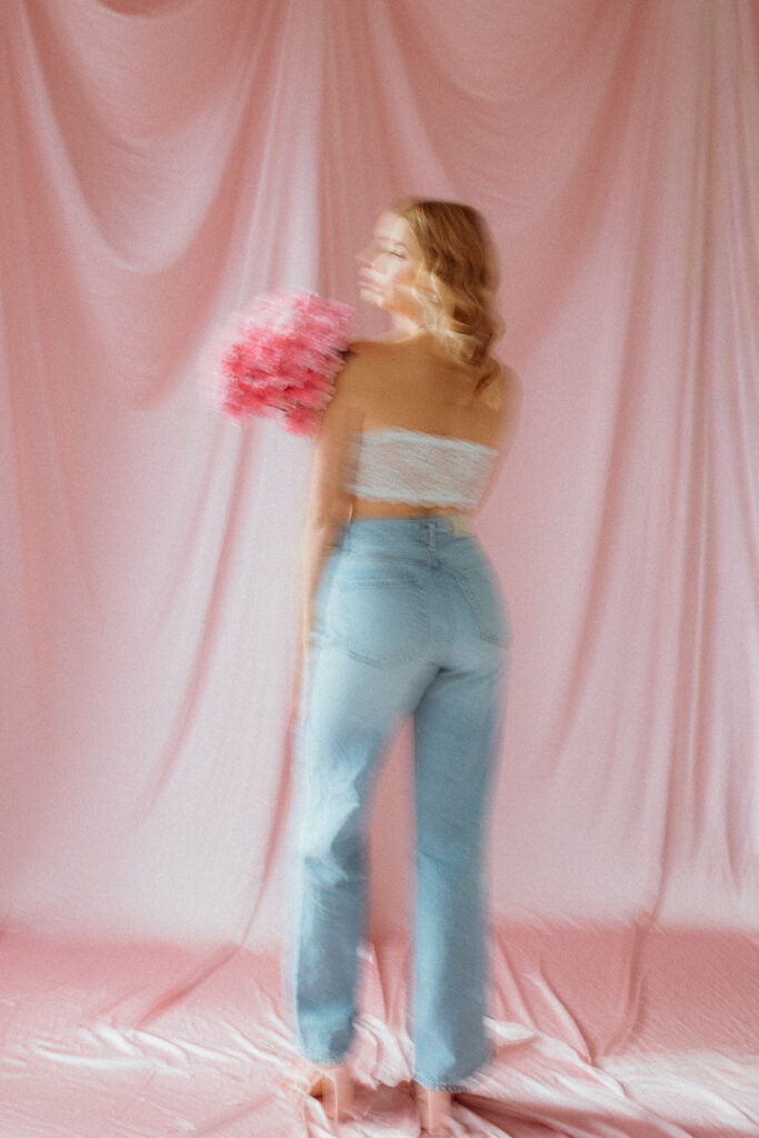 modelka ubrana na różowo, sesja z kwiatami z w studio