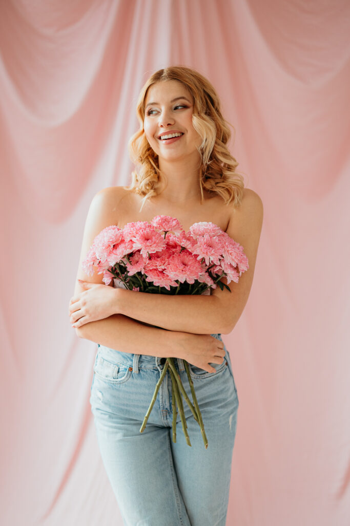 modelka ubrana na różowo, sesja z kwiatami z w studio