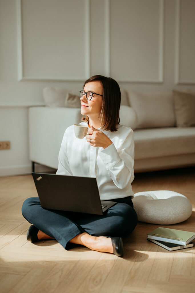 profesjonalna sesja wizerunkowa w studio dla marki osobistej, kobieta siedzi na podłodze z laptopem i kubkiem kawy