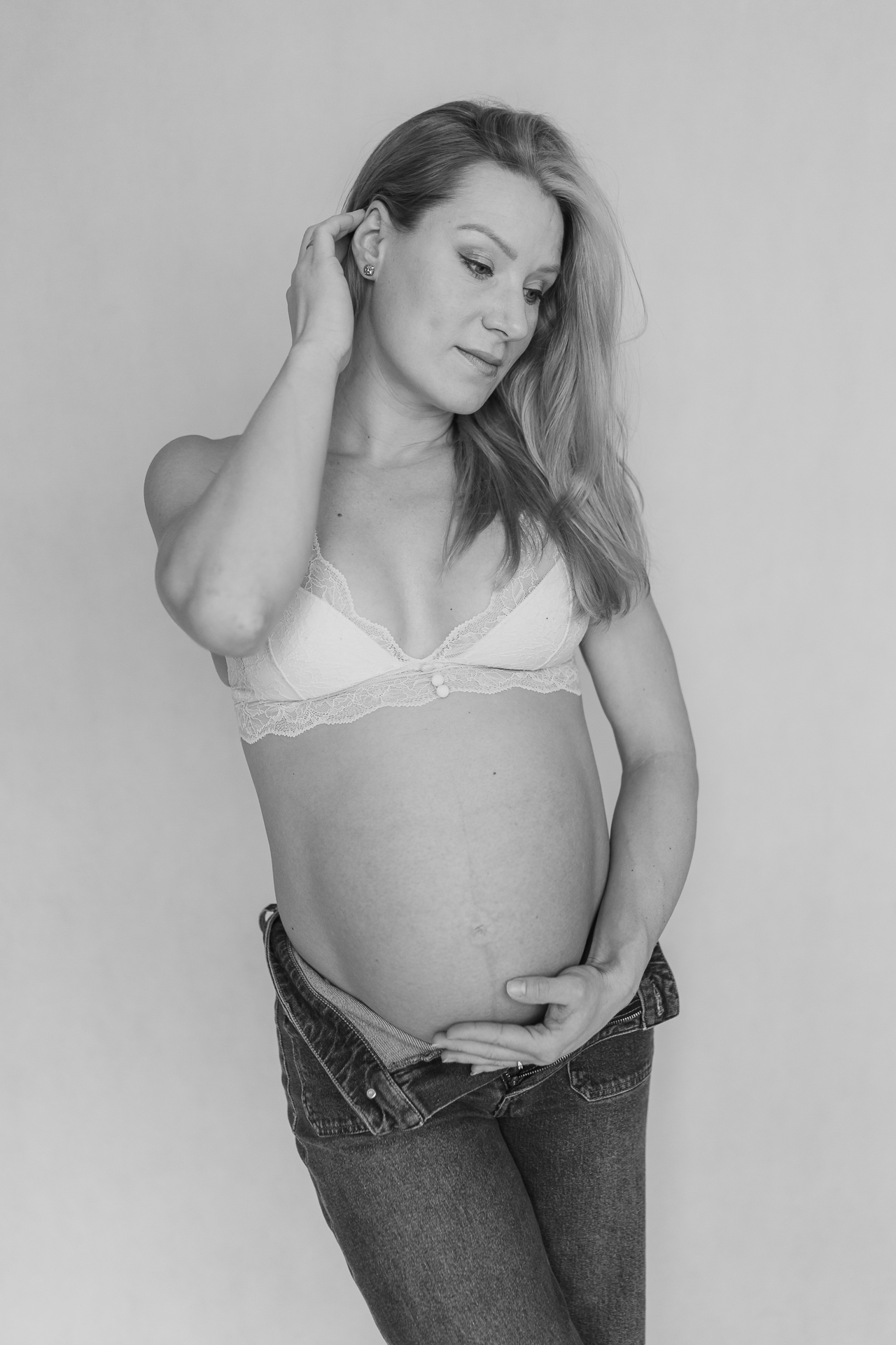 kobieta w białym biustonoszu z odsłoniętym brzuszkiem pozuje do zdjęcia w Krakowie